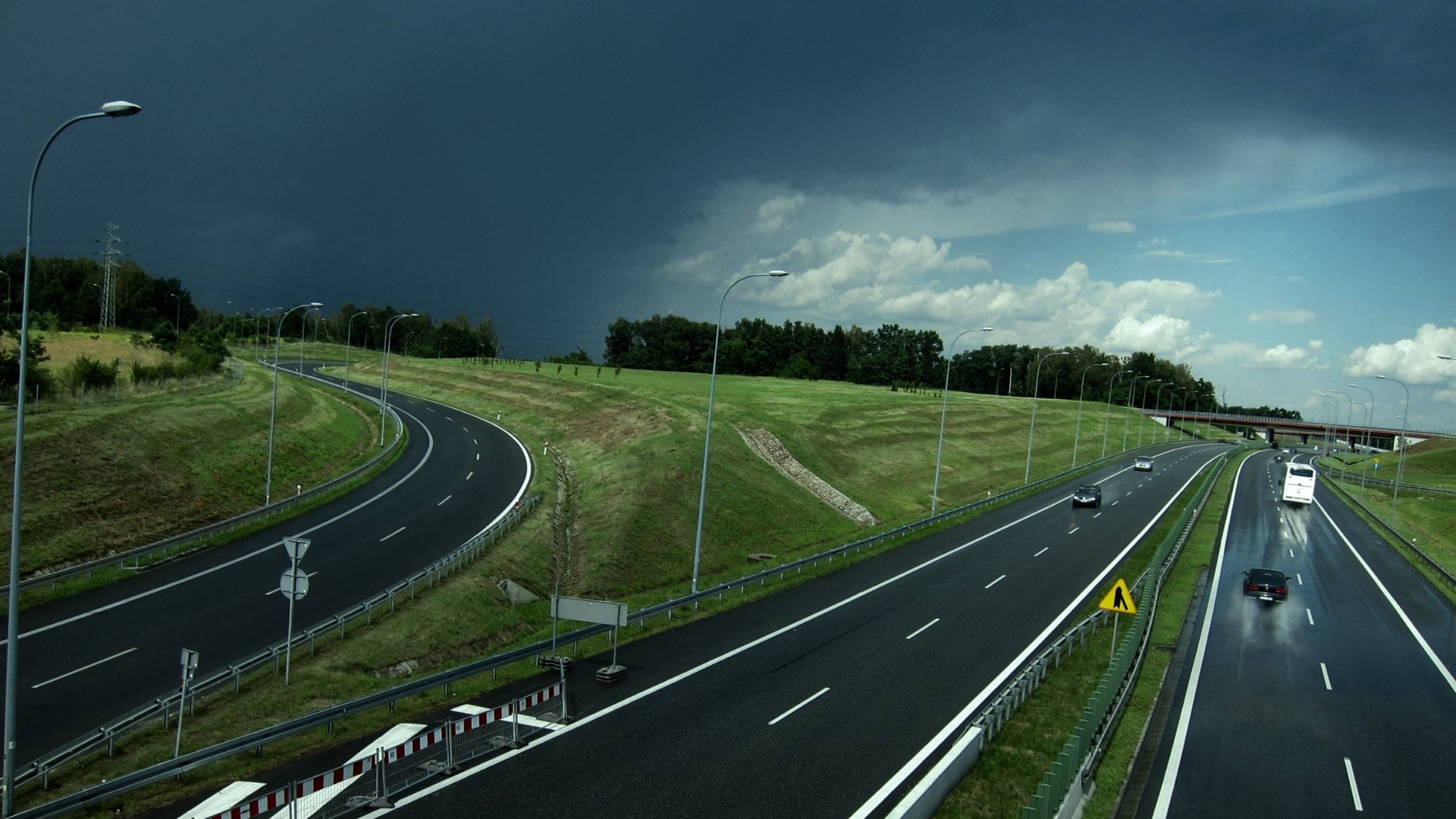 Highway with dark storm clouds and vehicles HD Wallpaper