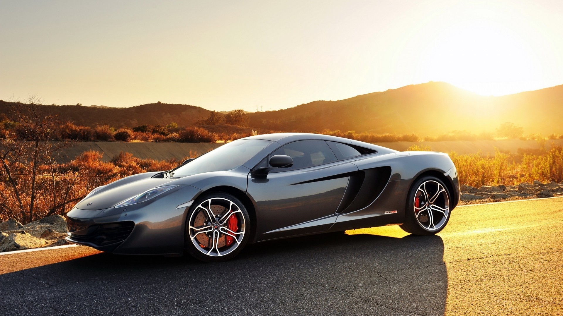 McLaren MP4-12C sports car on a road HD Wallpaper