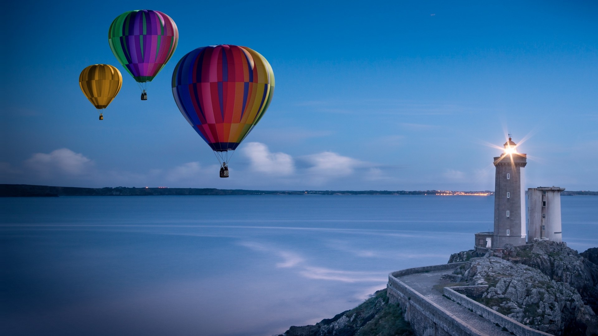 Hot air balloons over the sea at dusk with a lighthouse HD Wallpaper