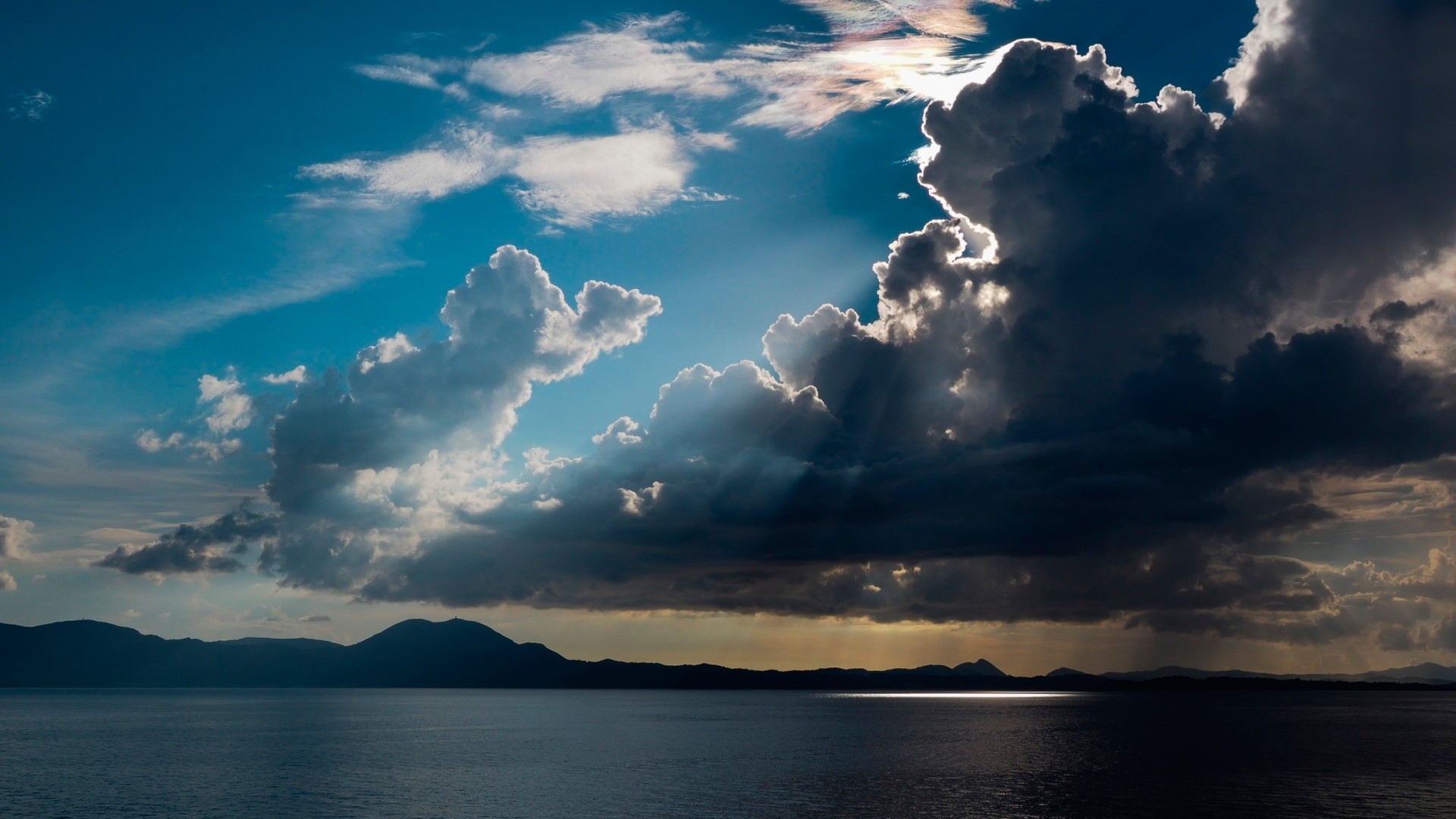 Dramatic clouds over the ocean and mountains HD Wallpaper