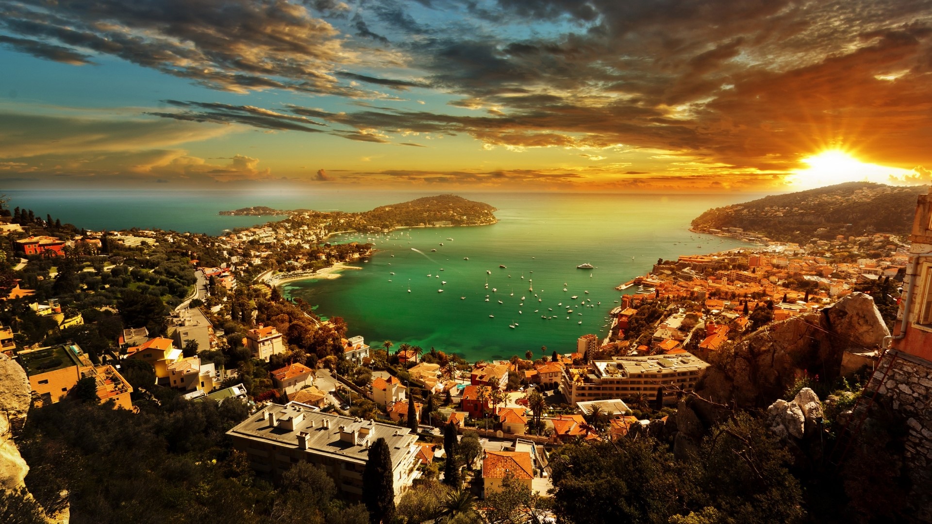 Sunset over a coastal town with boats HD Wallpaper