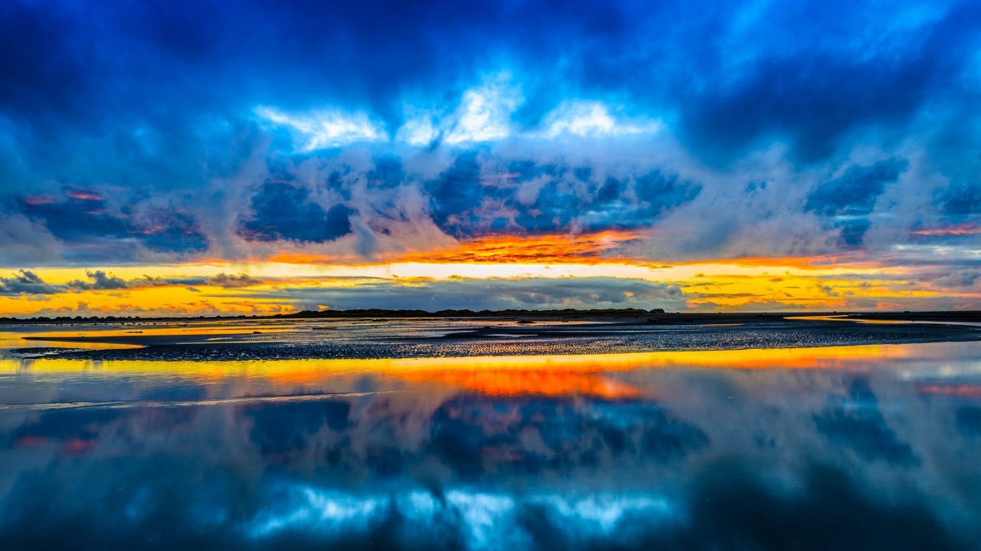 Sunset over a calm body of water with reflections HD Wallpaper