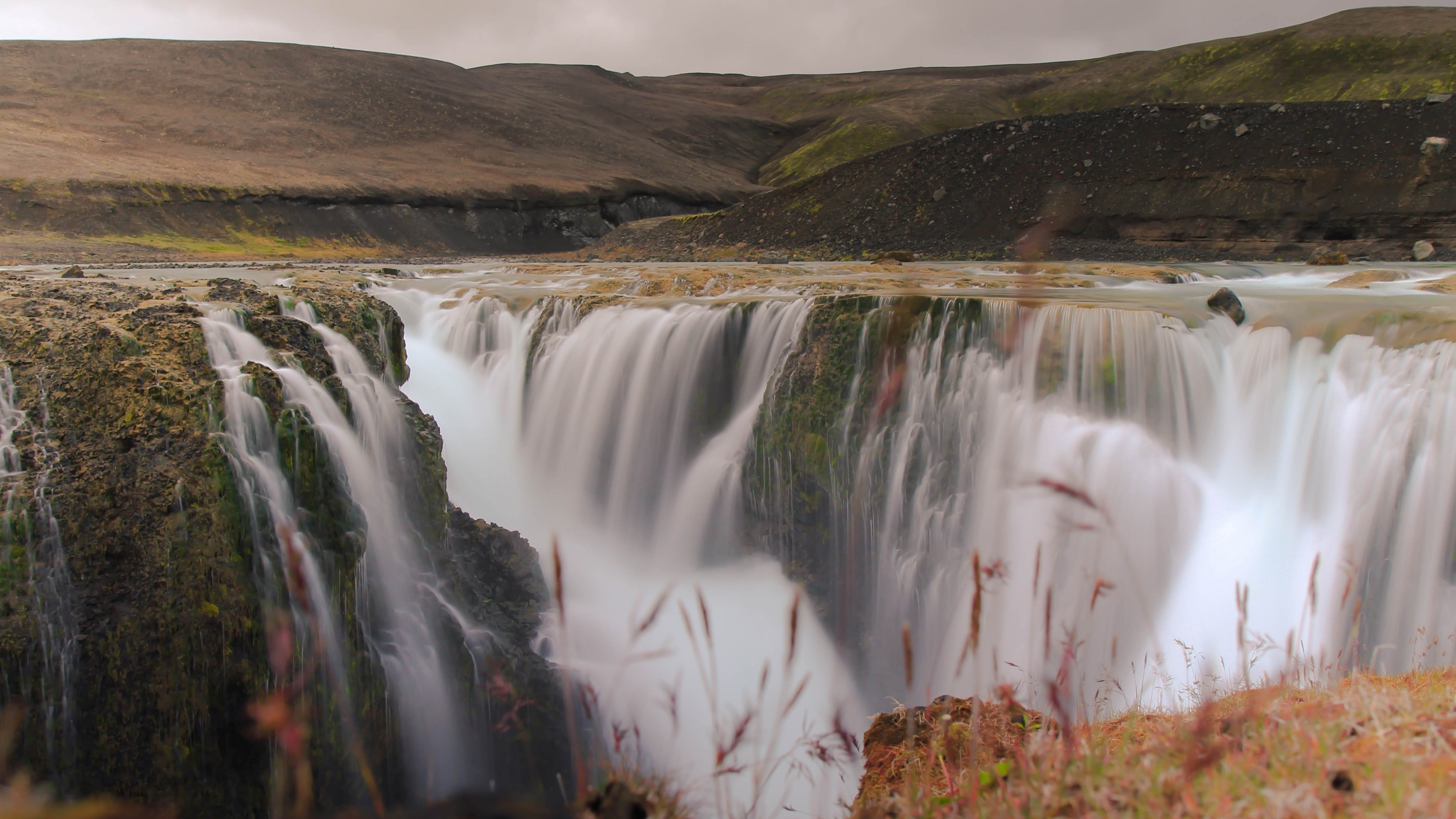 Waterfall cascade in a barren landscape HD Wallpaper