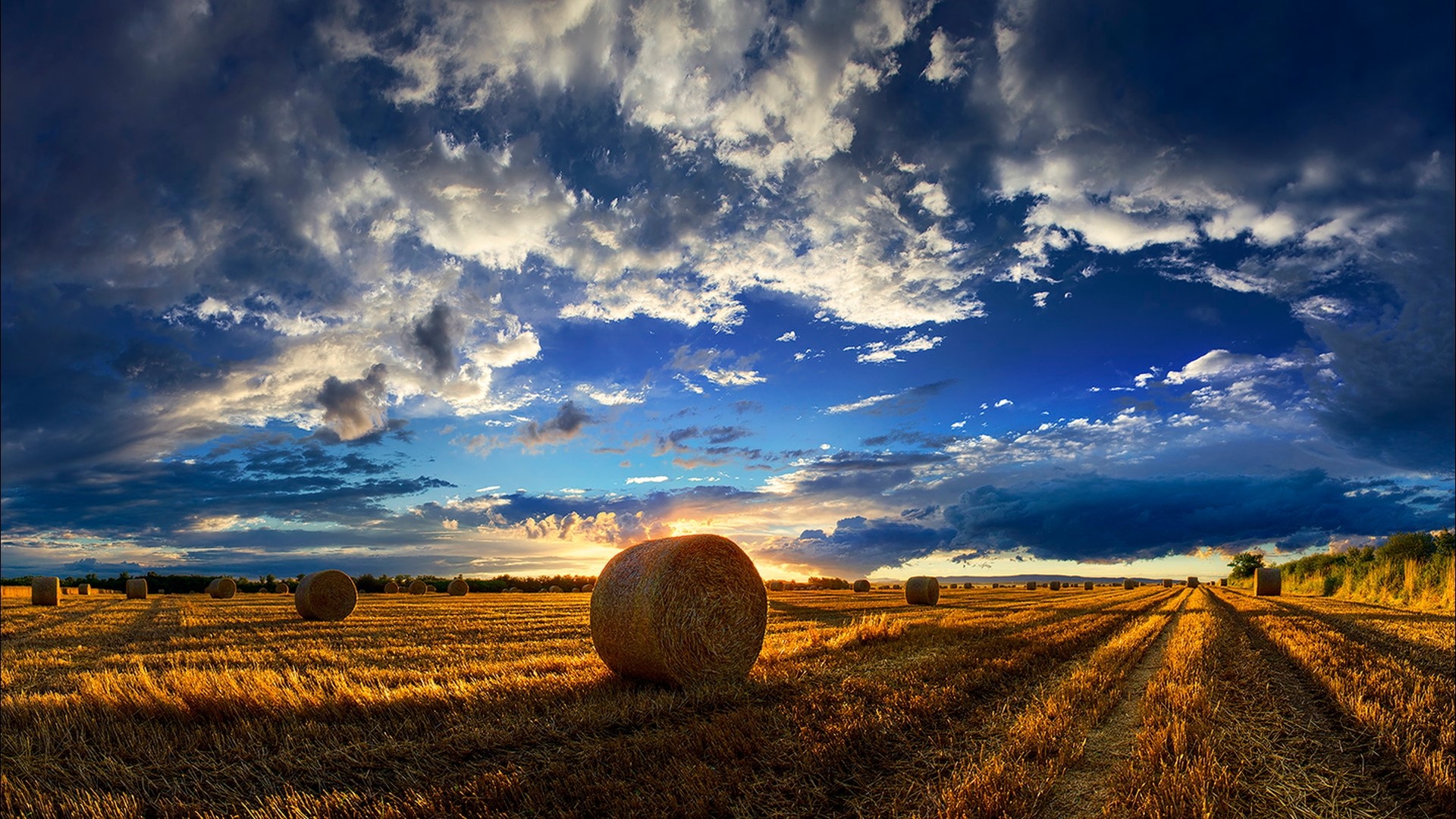Hay bales in a field at sunset HD Wallpaper
