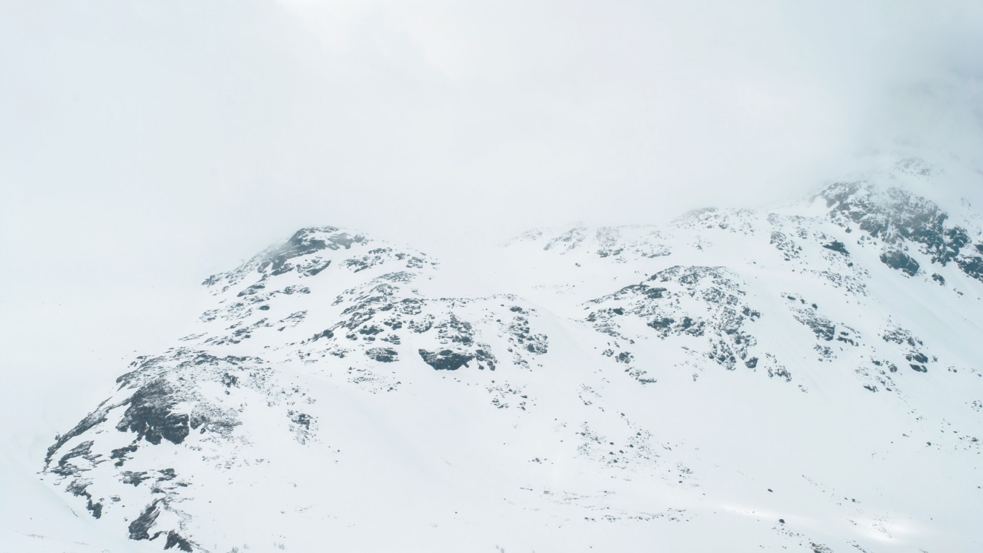 Snow-covered rocky mountains under clouds HD Wallpaper
