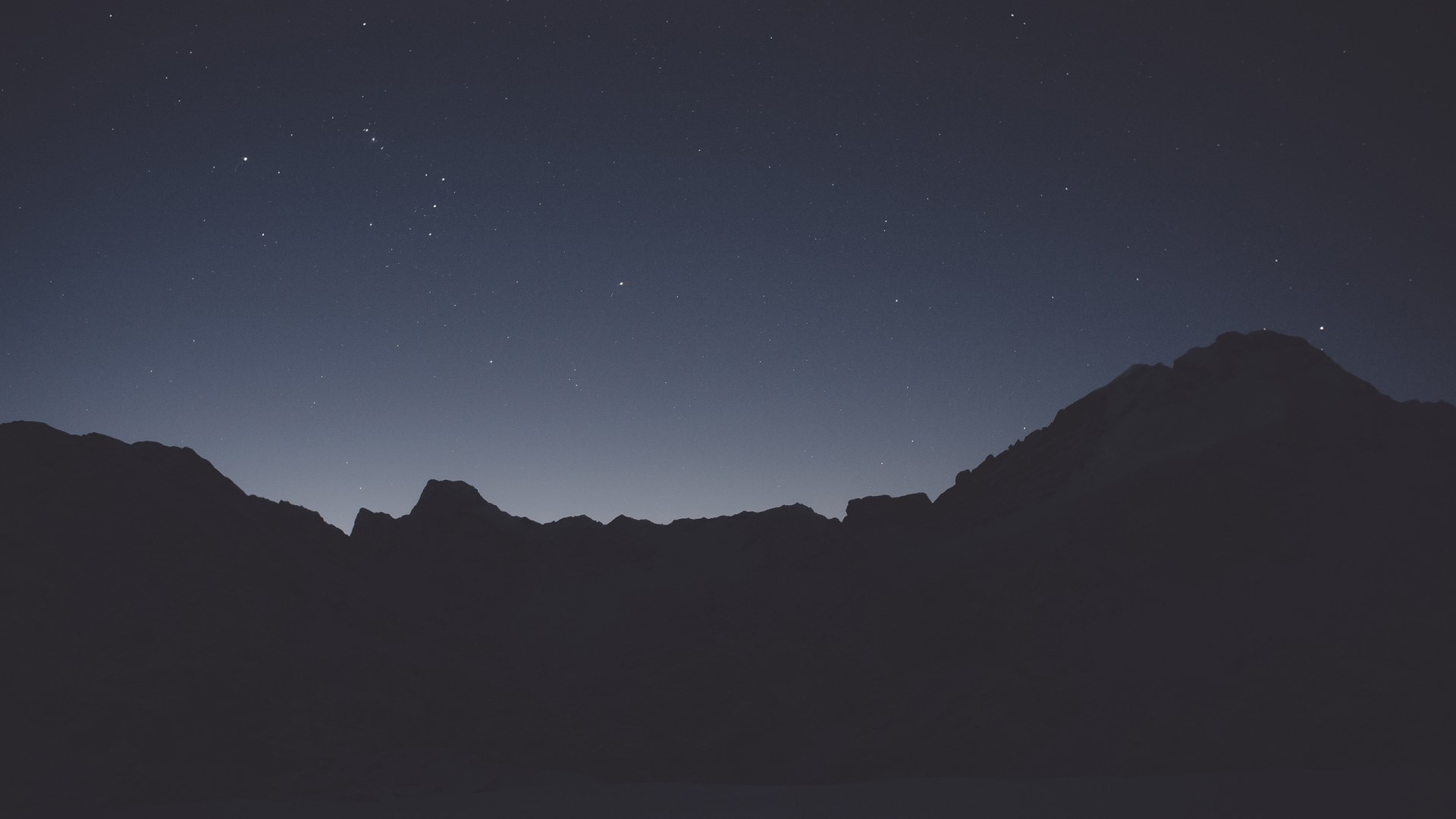 Mountain silhouette against starry night sky HD Wallpaper