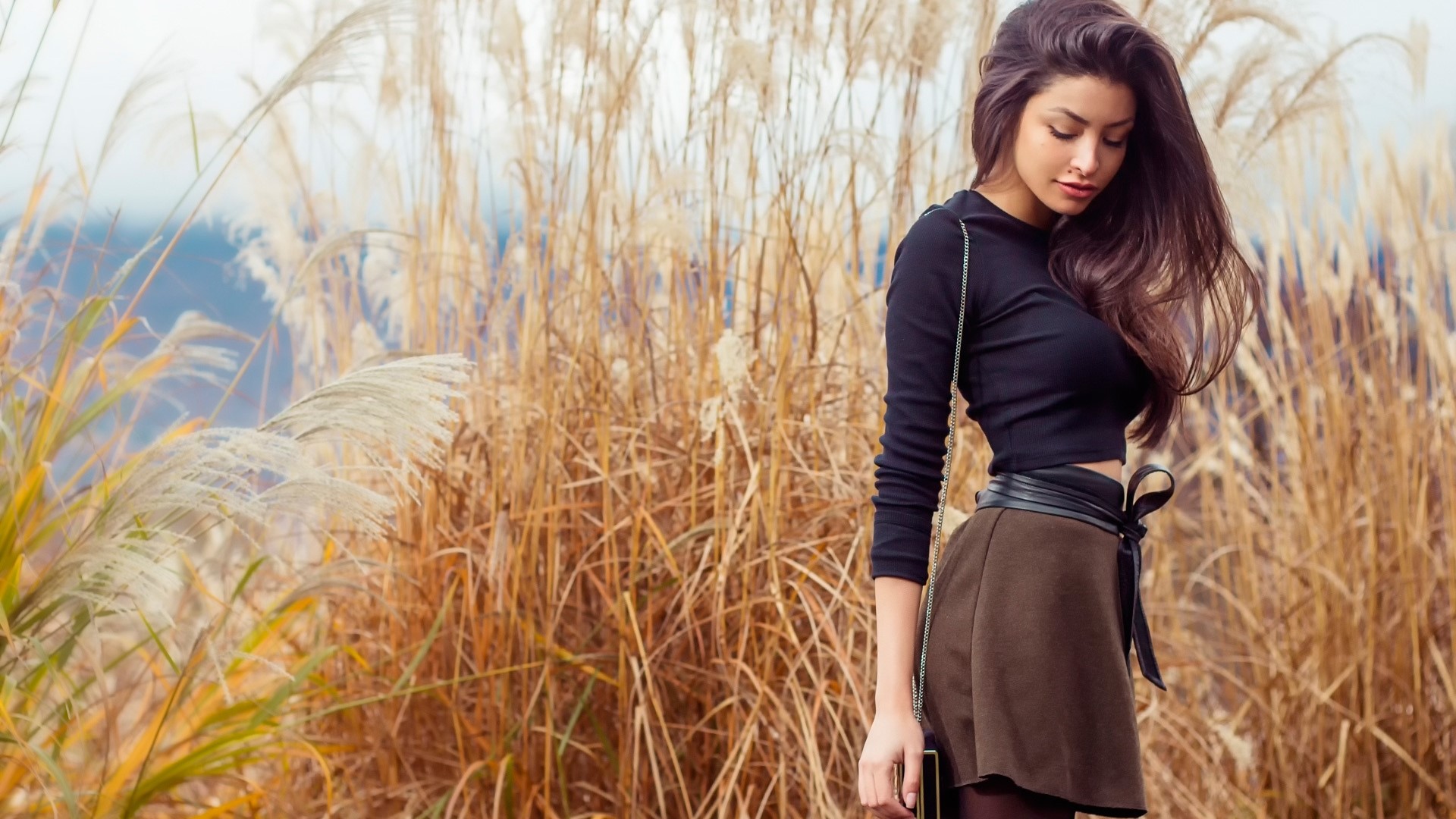 Woman in black top and brown skirt in tall grass HD Wallpaper