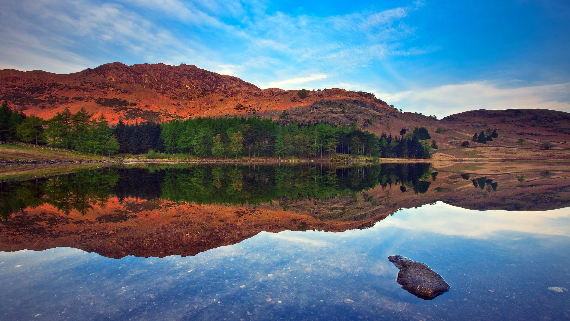 Mountains reflected in a lake at sunset HD Wallpaper