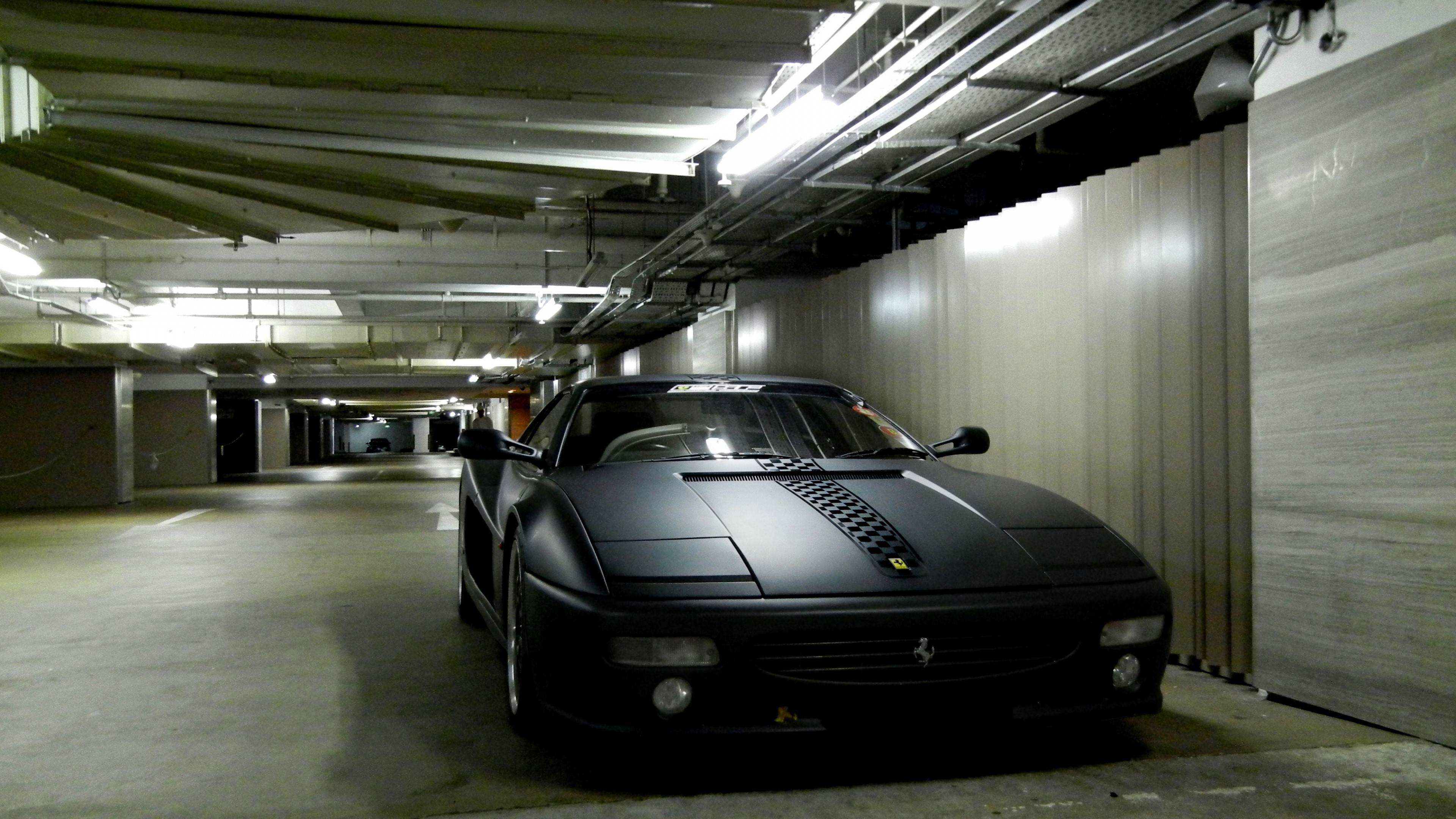 Matte black Ferrari in a parking garage HD Wallpaper