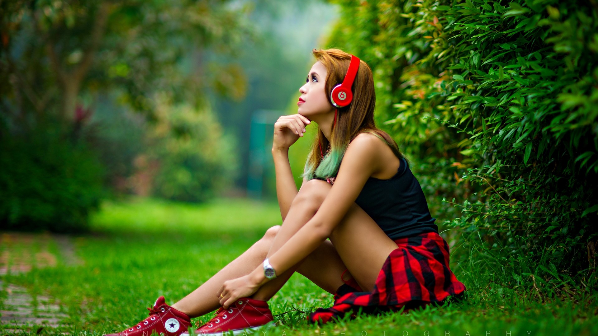 Girl with headphones sitting in a park HD Wallpaper