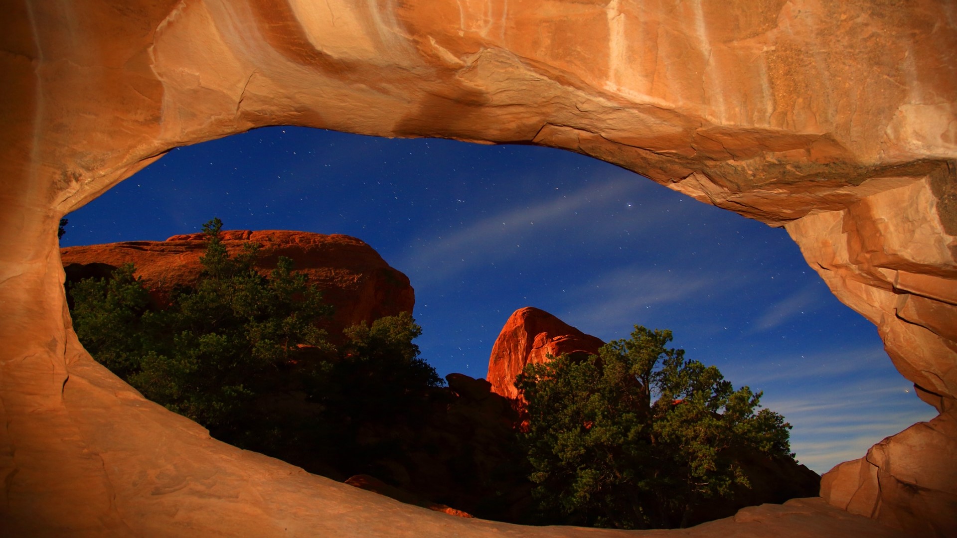 Night sky seen through a sandstone arch HD Wallpaper
