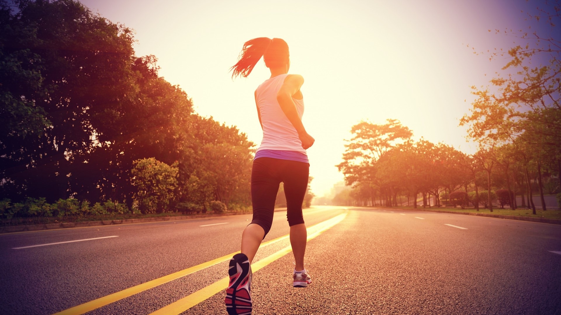 Woman running on a road at sunset HD Wallpaper
