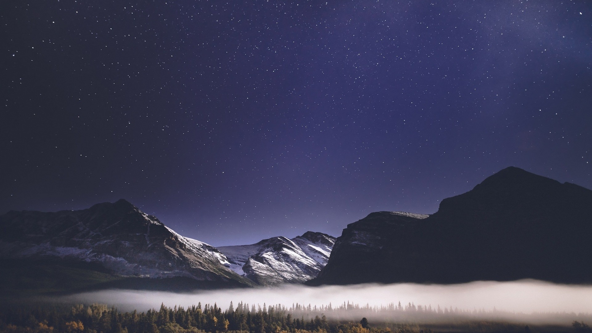 Starry night sky over misty mountains and forest HD Wallpaper