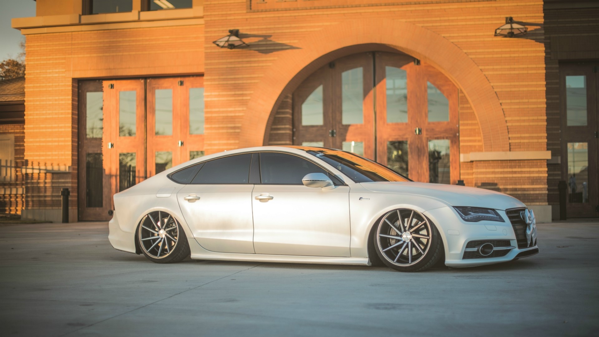 White Audi A7 parked in front of a brick building HD Wallpaper