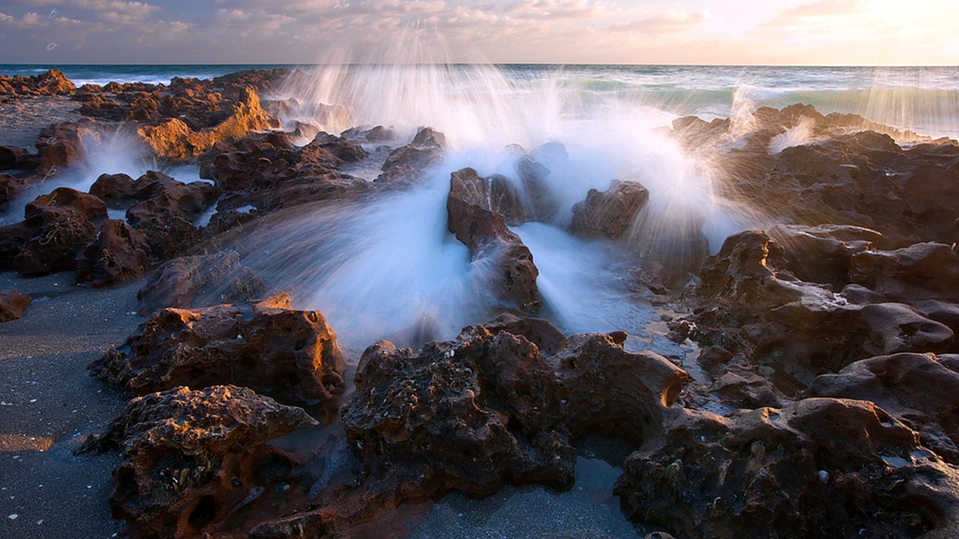 Waves crashing on rocky shore at sunset HD Wallpaper