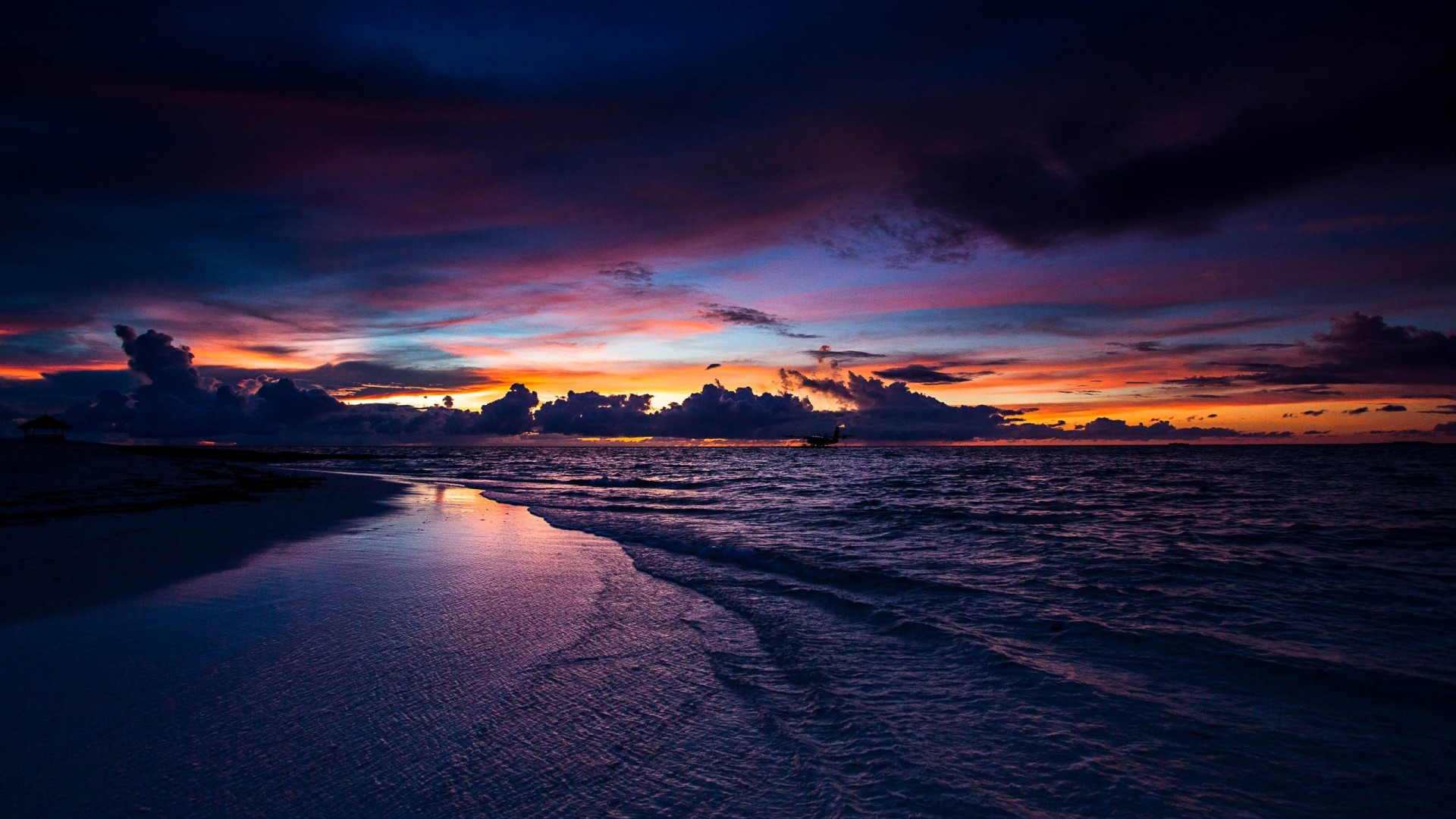 Sunset over the ocean with colorful clouds and beach HD Wallpaper