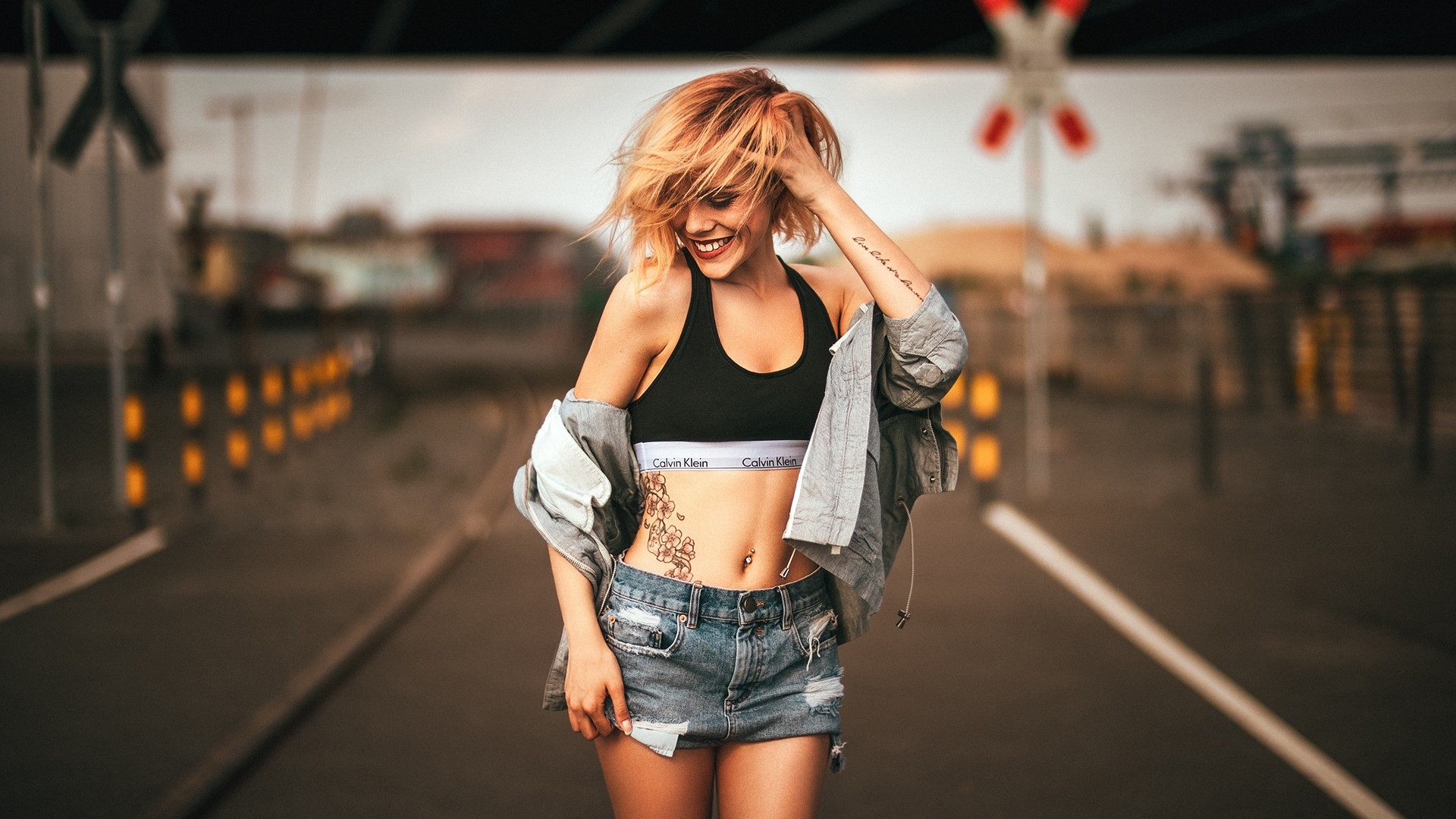 Woman with tattoos wearing Calvin Klein bra and denim shorts HD Wallpaper