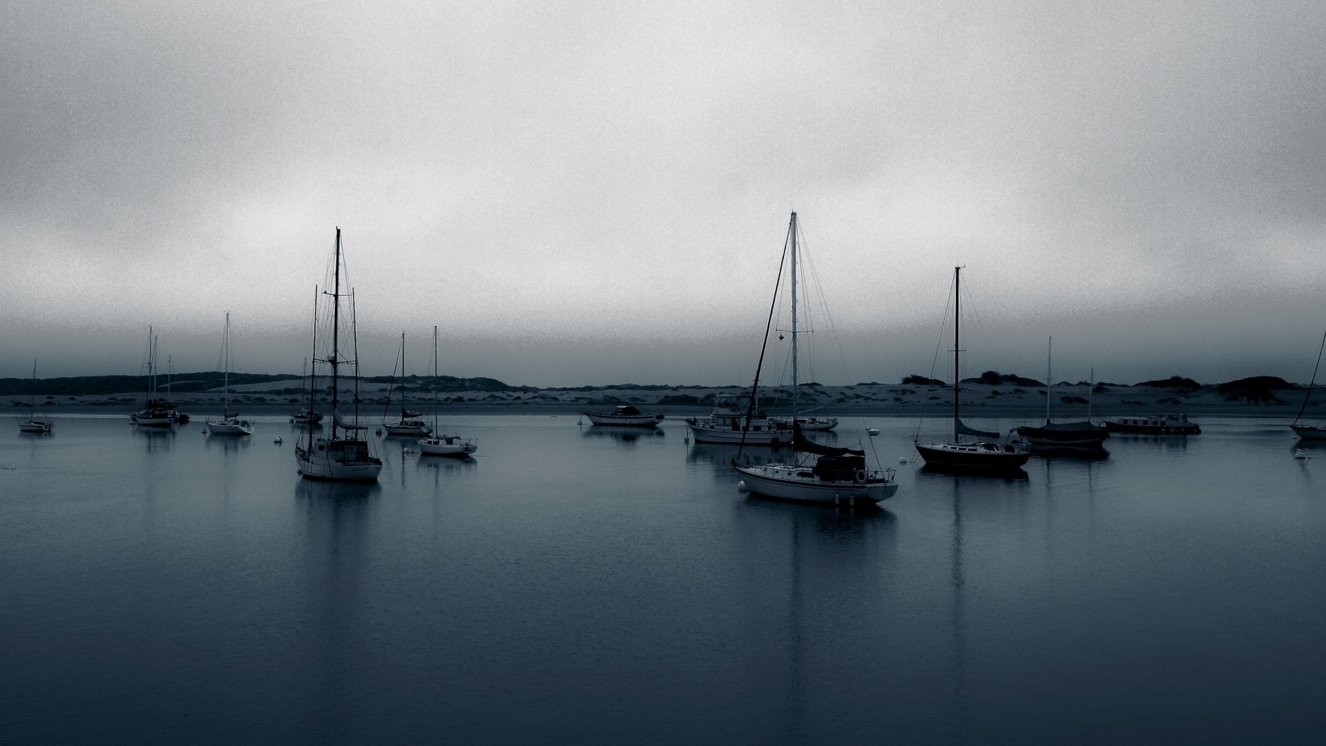 Sailboats moored in a calm bay under a cloudy sky HD Wallpaper