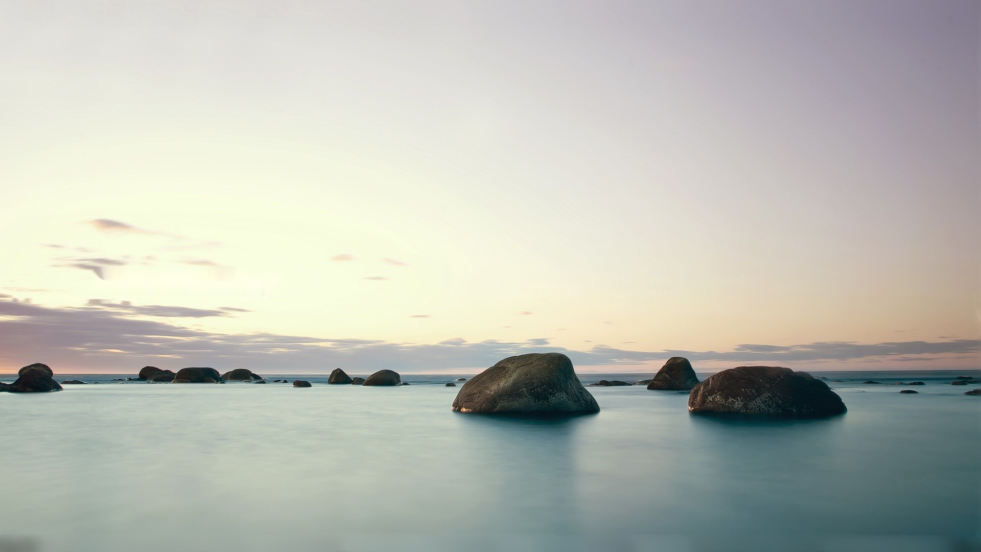 Rocks in the ocean at sunrise HD Wallpaper