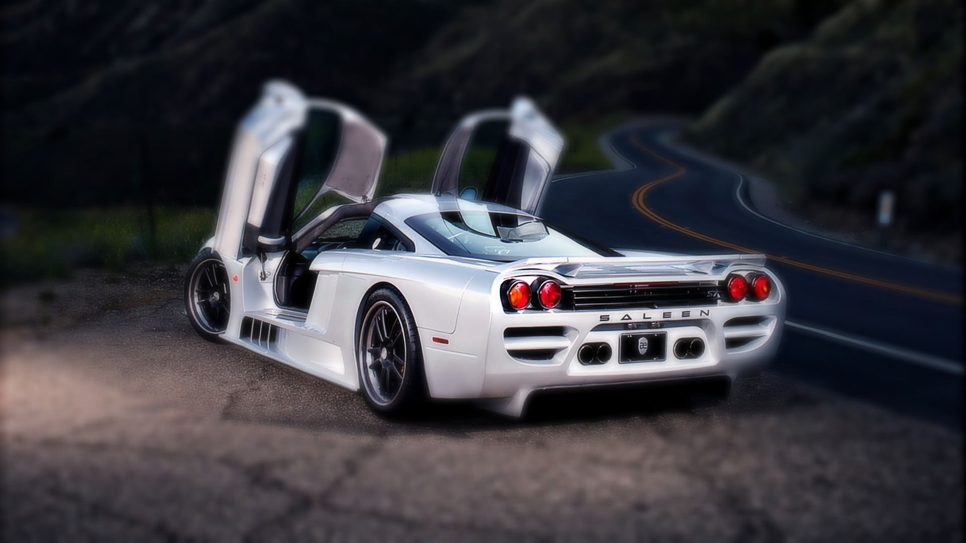 White Saleen S7 Twin Turbo with Butterfly Doors on a Winding Road HD Wallpaper