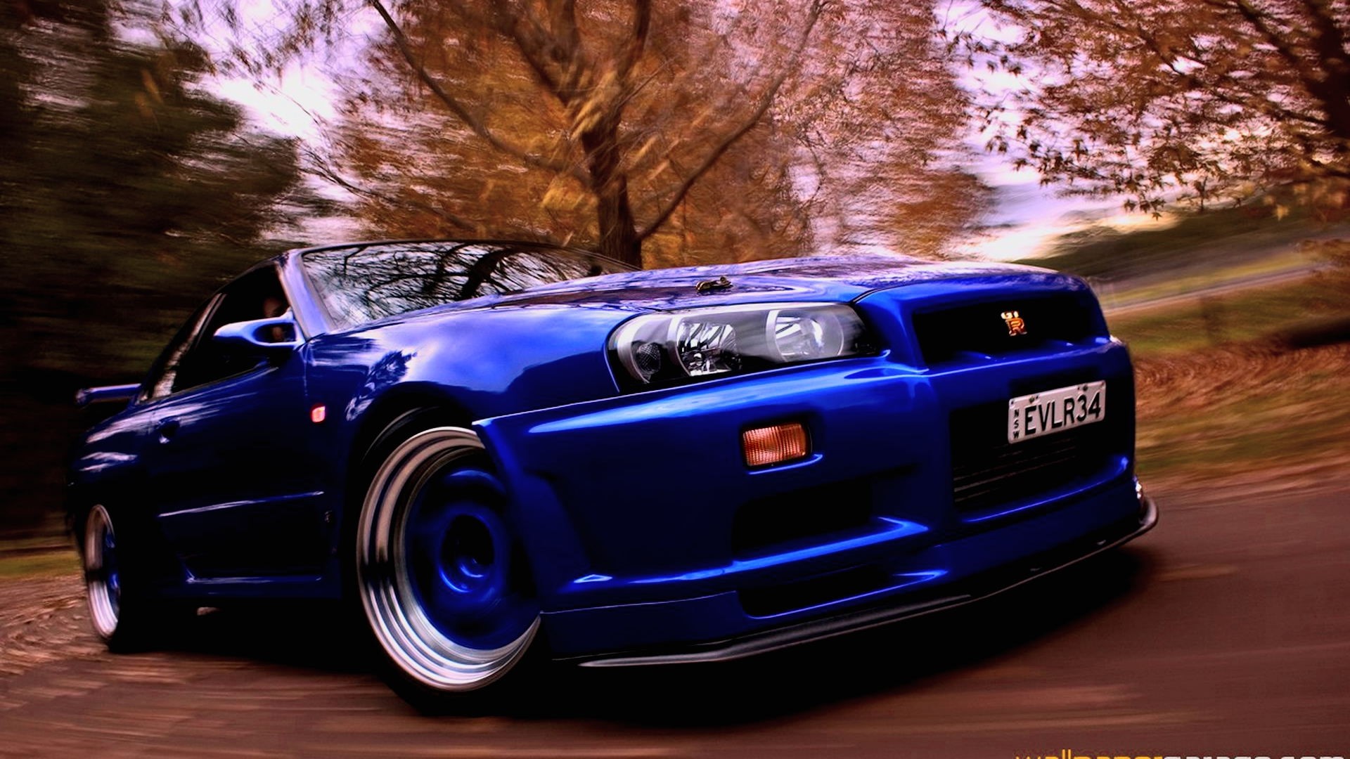 Blue Nissan GT-R R34 driving on a road HD Wallpaper
