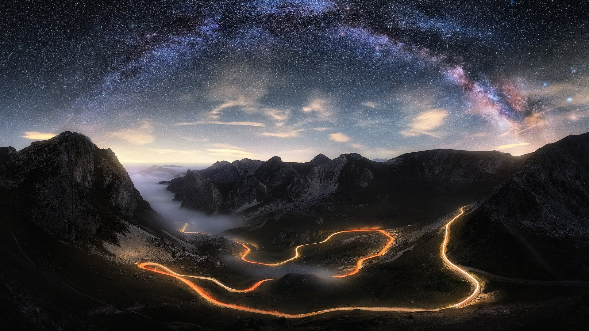 Milky Way over winding mountain road at night HD Wallpaper