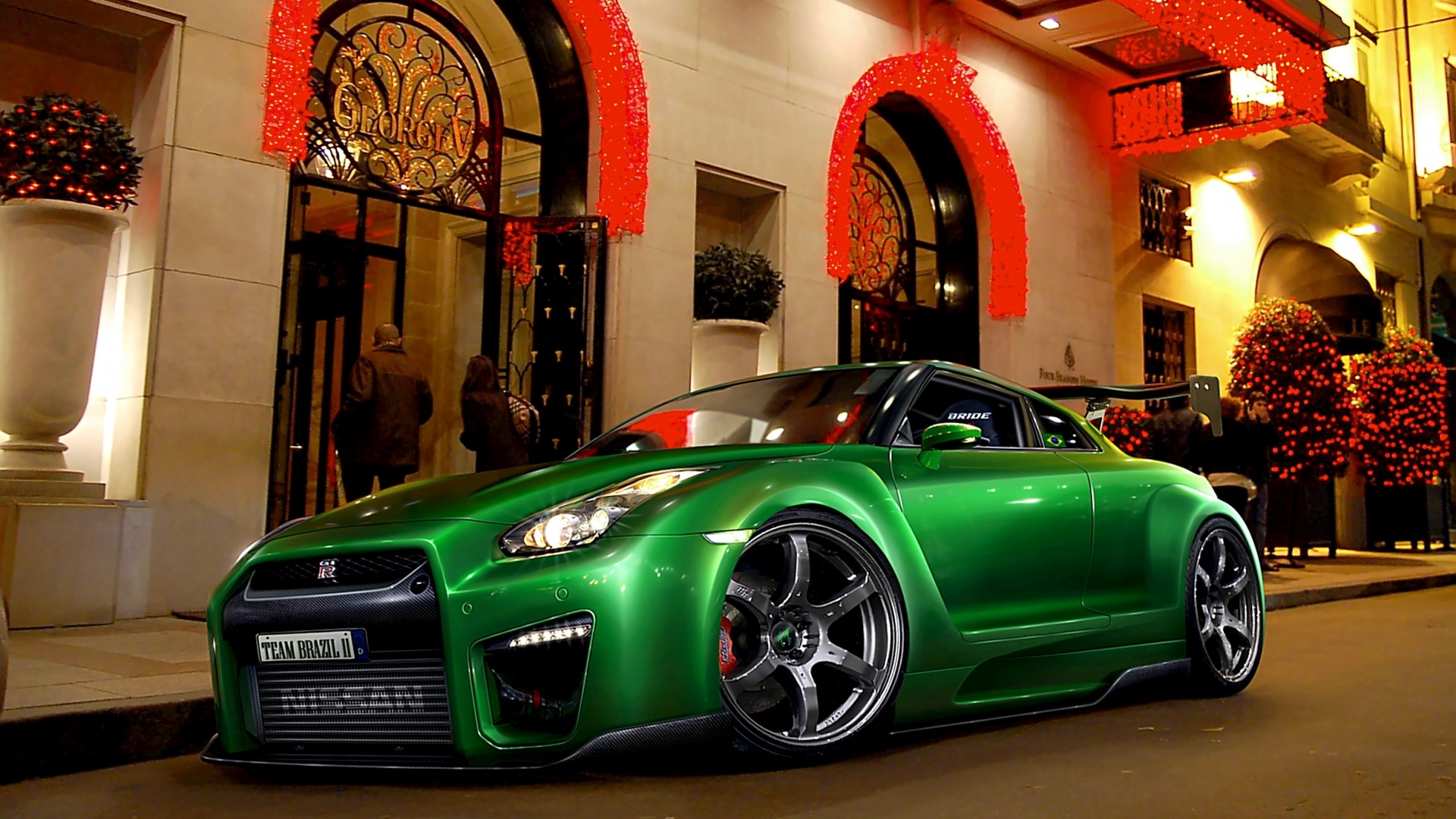 Green Nissan GT-R in front of a building HD Wallpaper