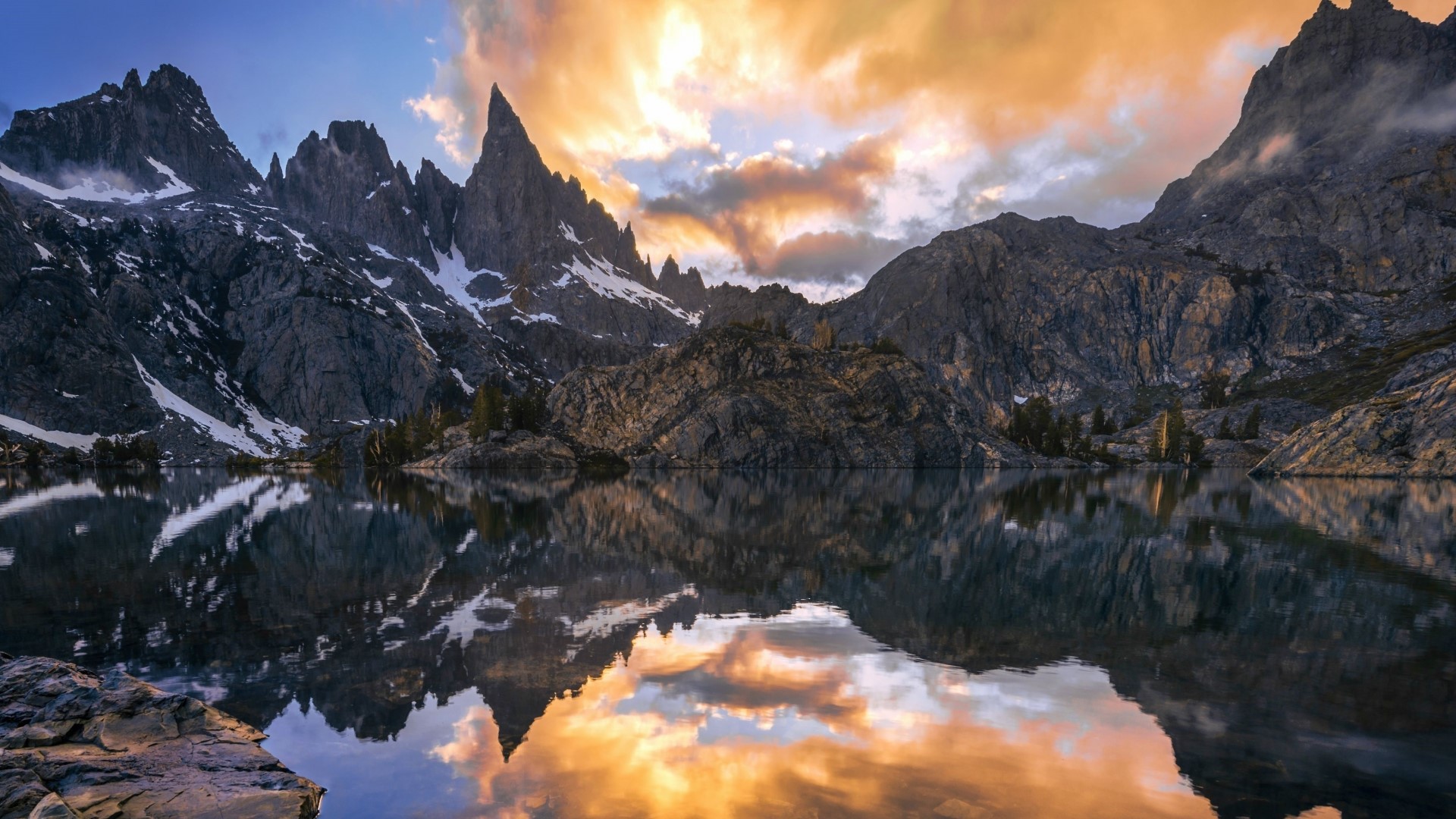 Mountain peaks reflected in a lake at sunset HD Wallpaper