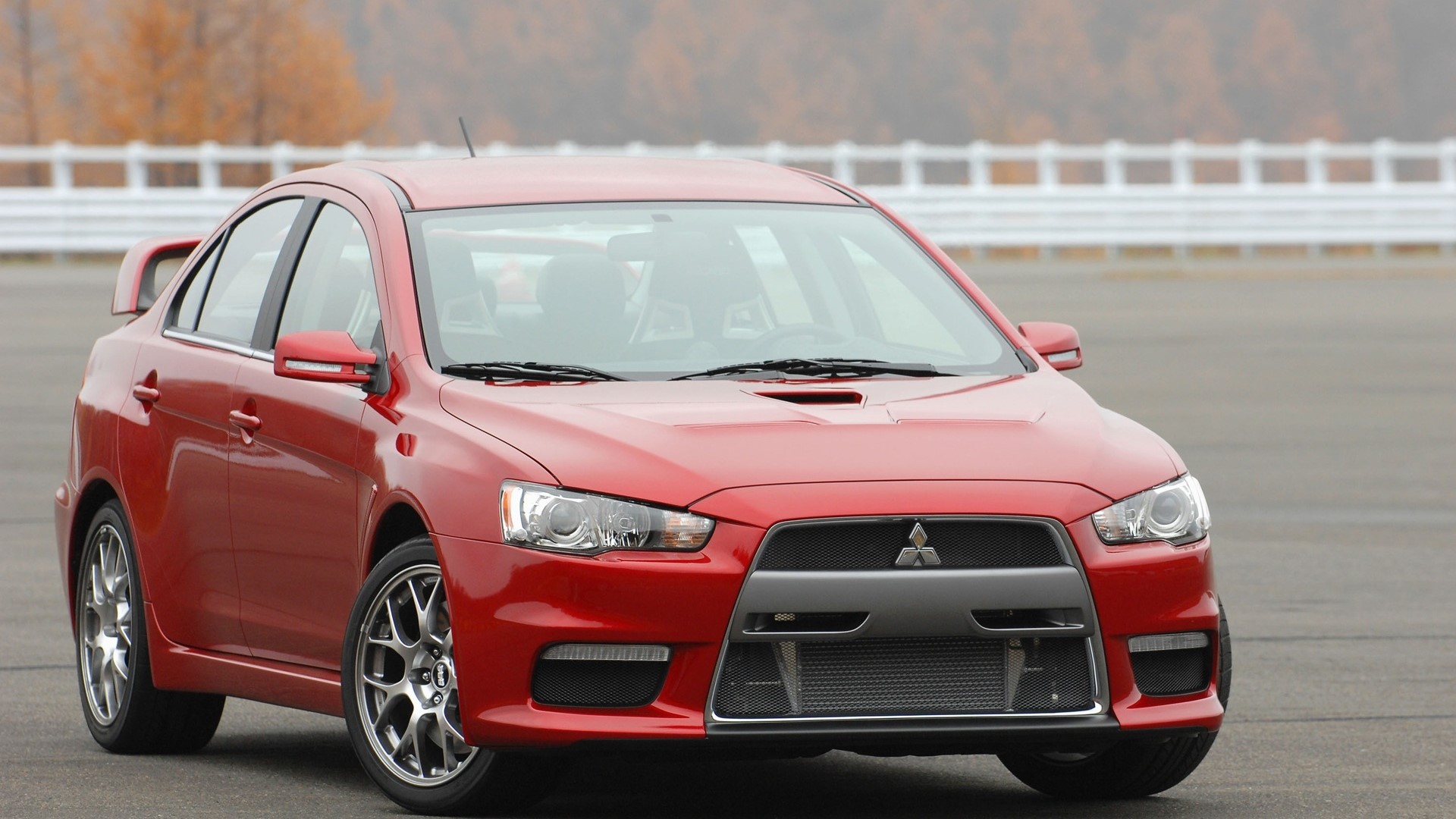 Red Mitsubishi Lancer Evolution X on a Racetrack HD Wallpaper