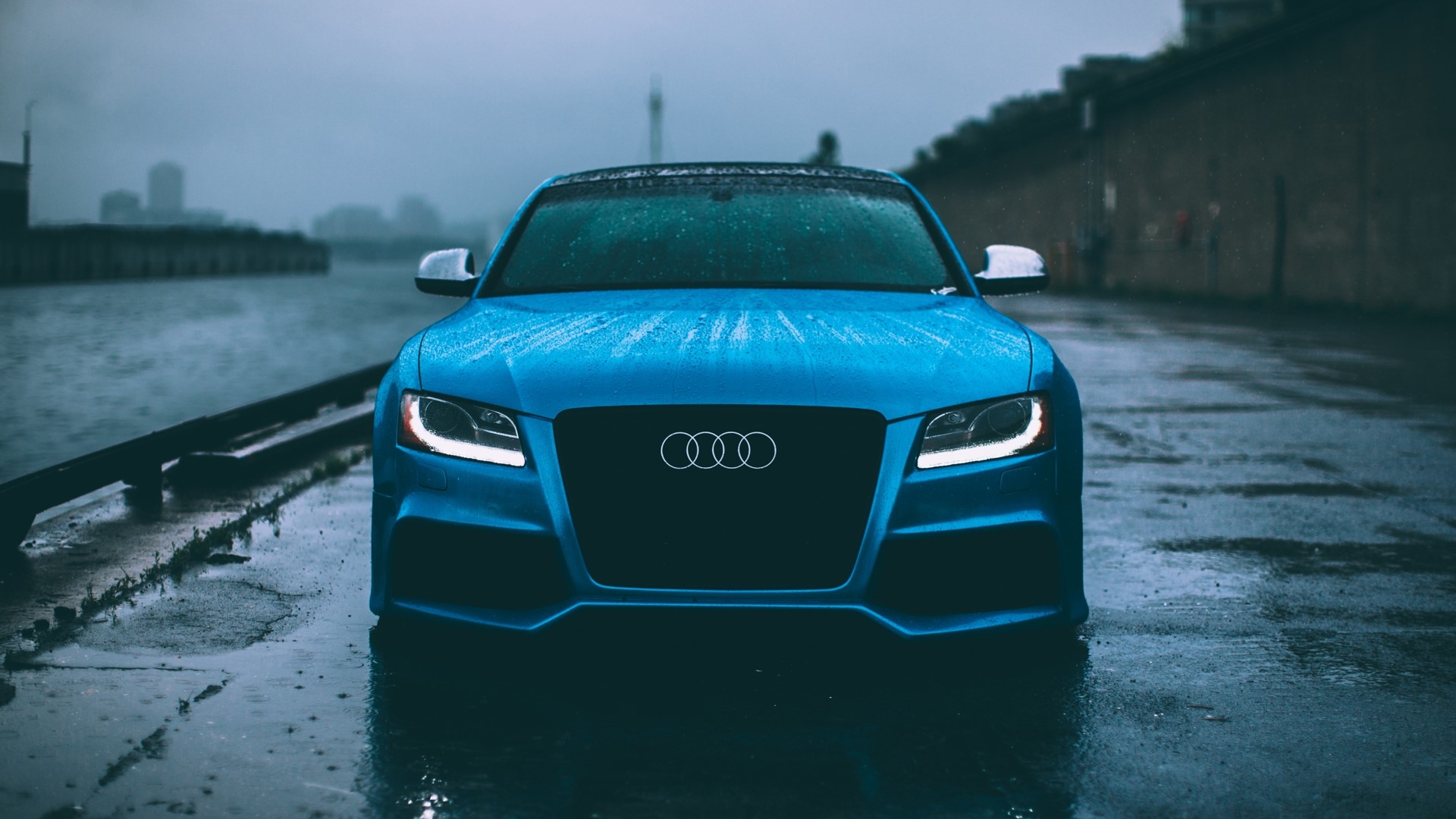 Blue Audi S5 parked by water on a rainy day HD Wallpaper