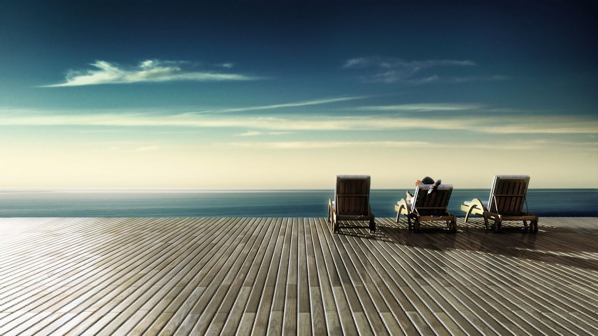 People relaxing on lounge chairs by the ocean HD Wallpaper