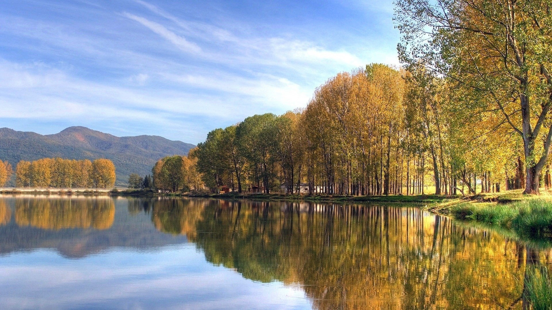 Autumn trees reflected in a calm lake with mountains HD Wallpaper
