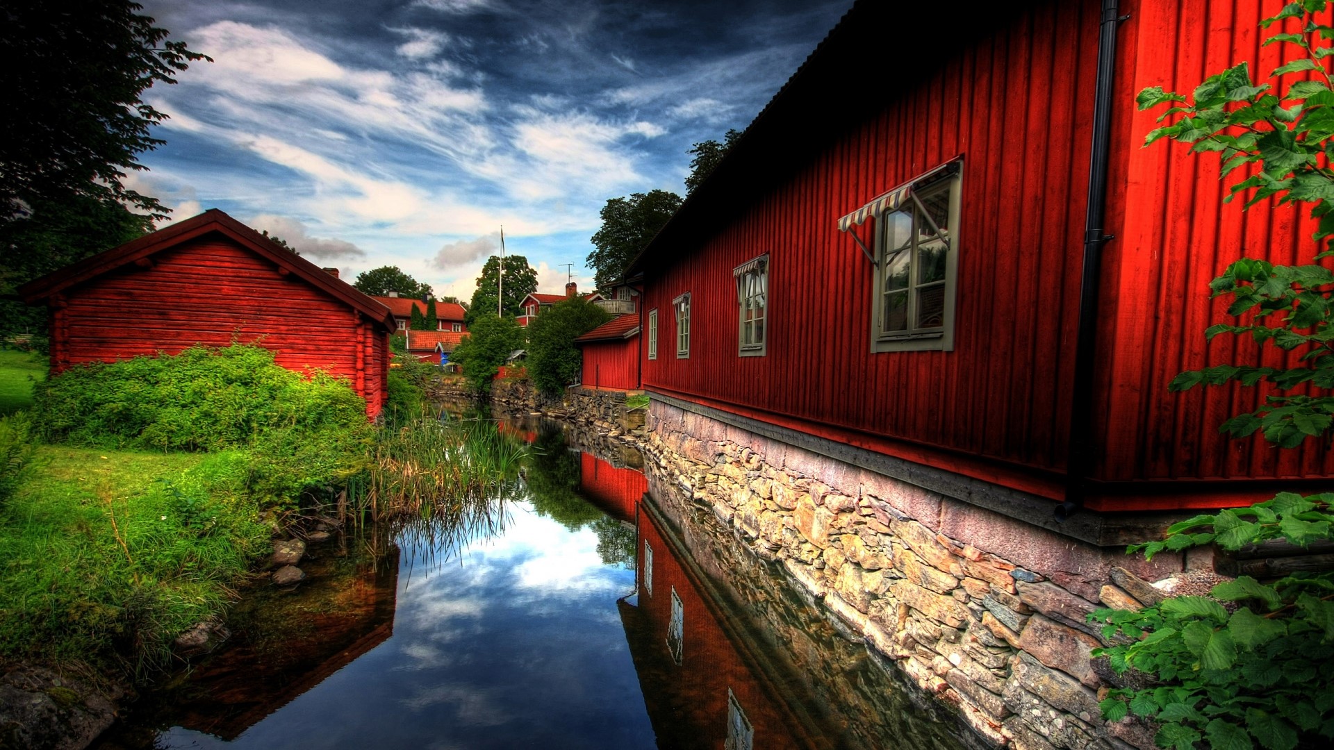 Red wooden houses by a canal HD Wallpaper