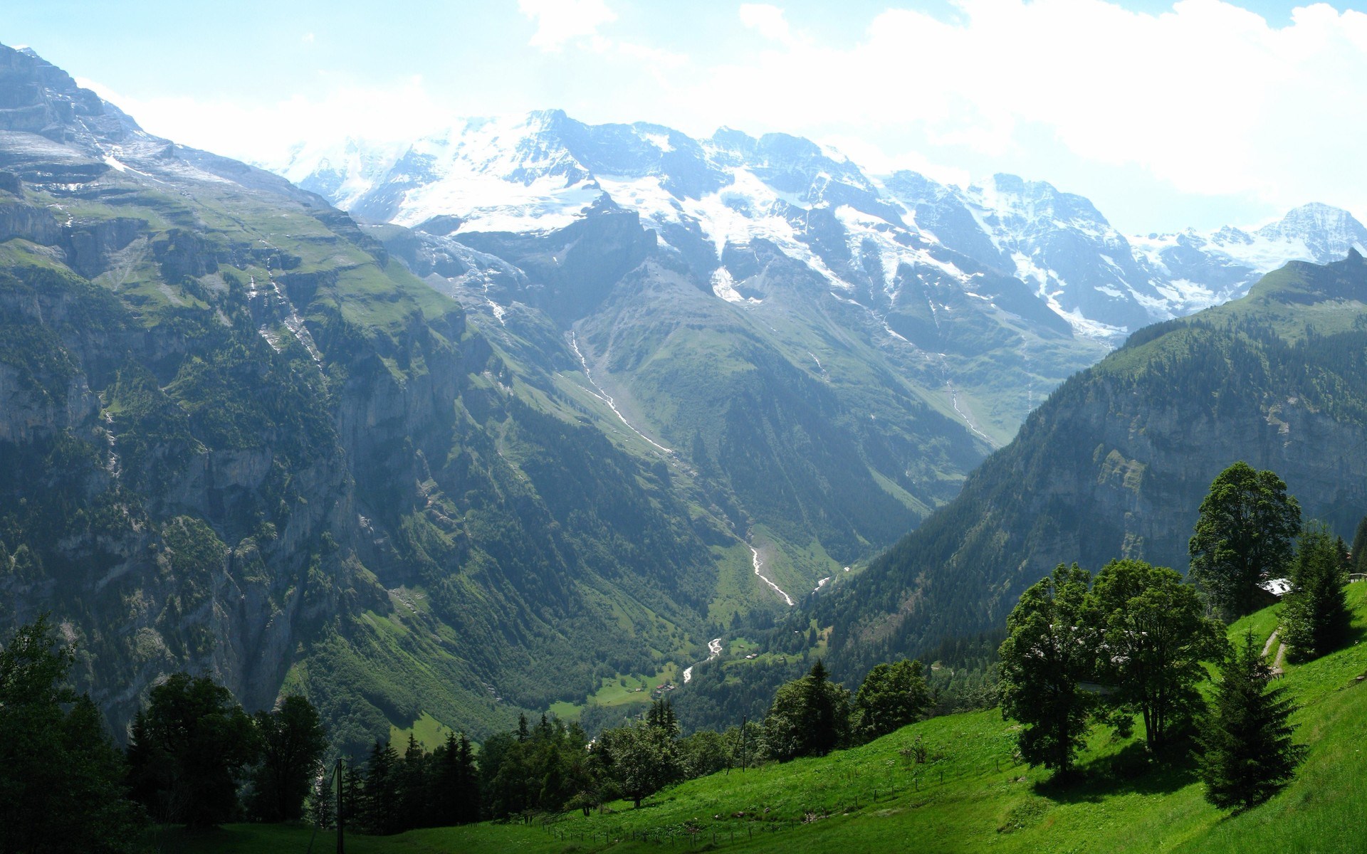Snow-capped mountains and a green valley HD Wallpaper