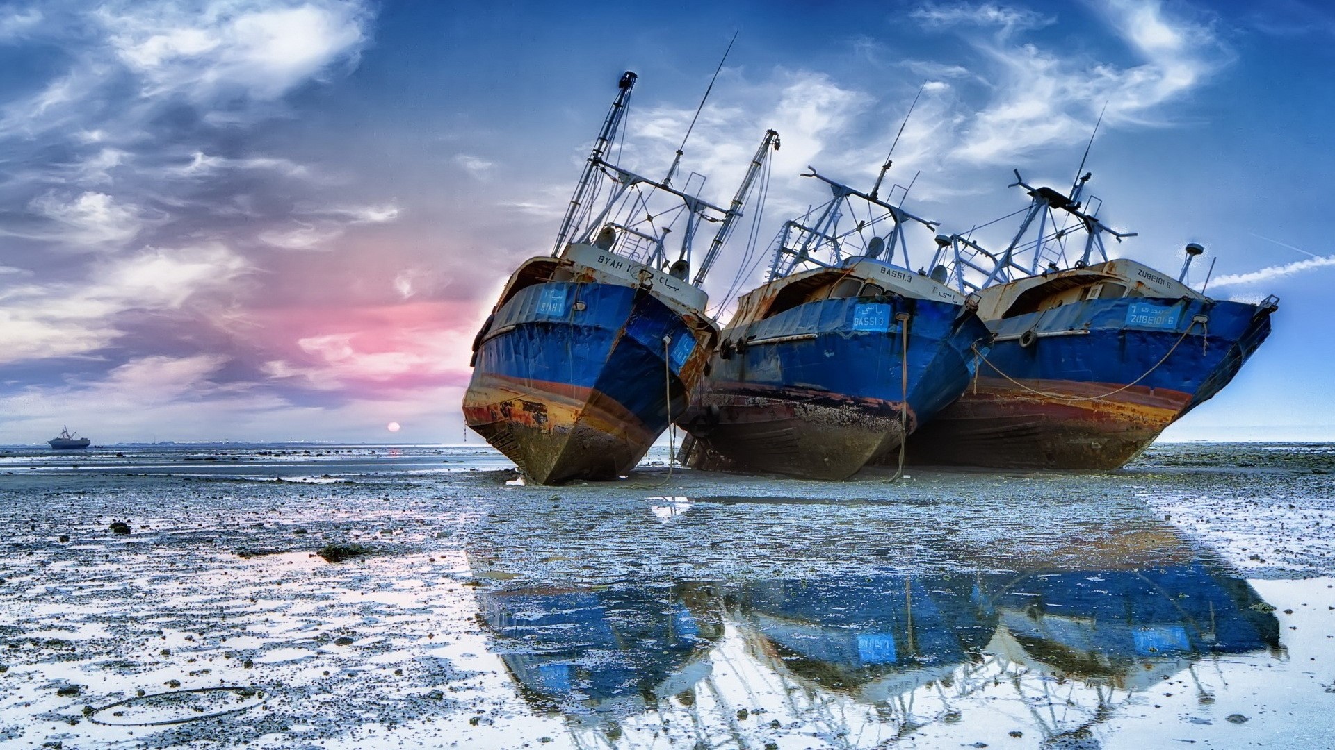 Shipwrecked boats on a muddy shore at sunset HD Wallpaper