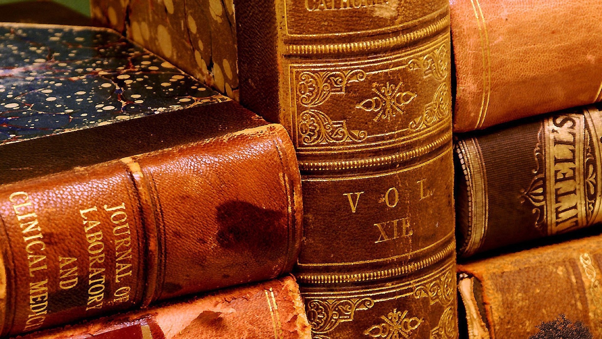 Stack of antique leather-bound books HD Wallpaper