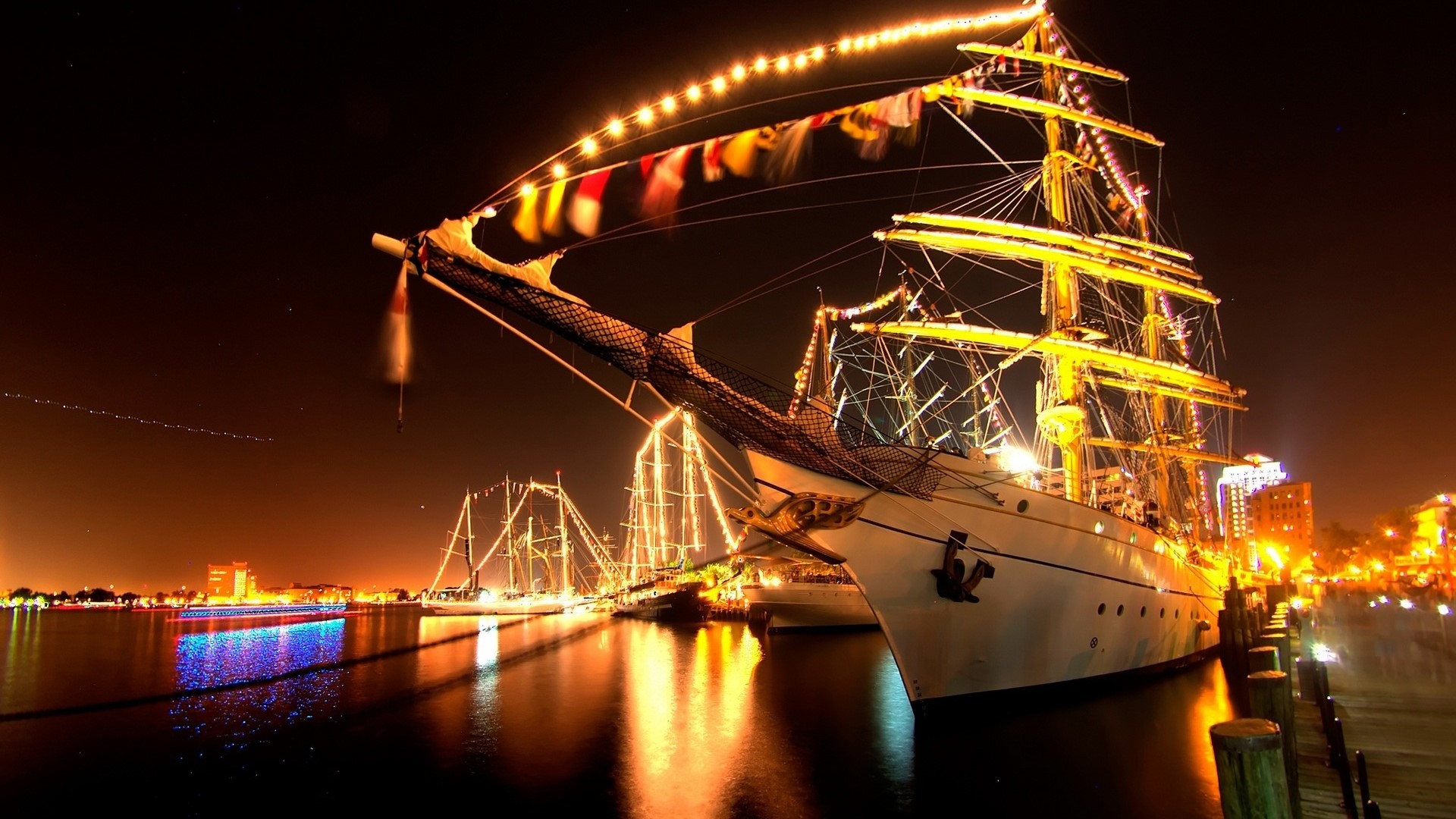 Tall ships decorated with lights at night HD Wallpaper
