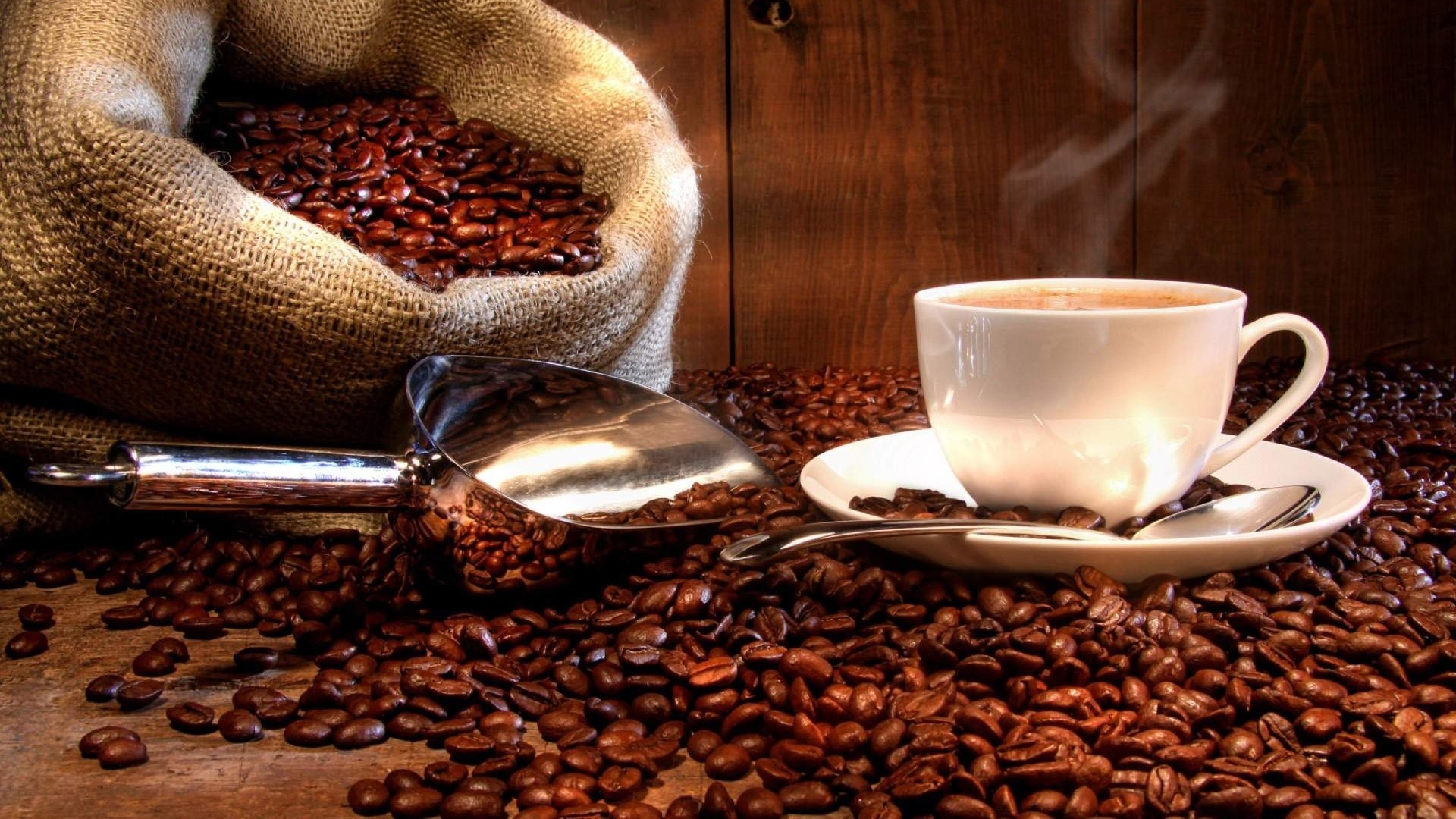 Roasted coffee beans in a burlap sack with a cup of coffee HD Wallpaper