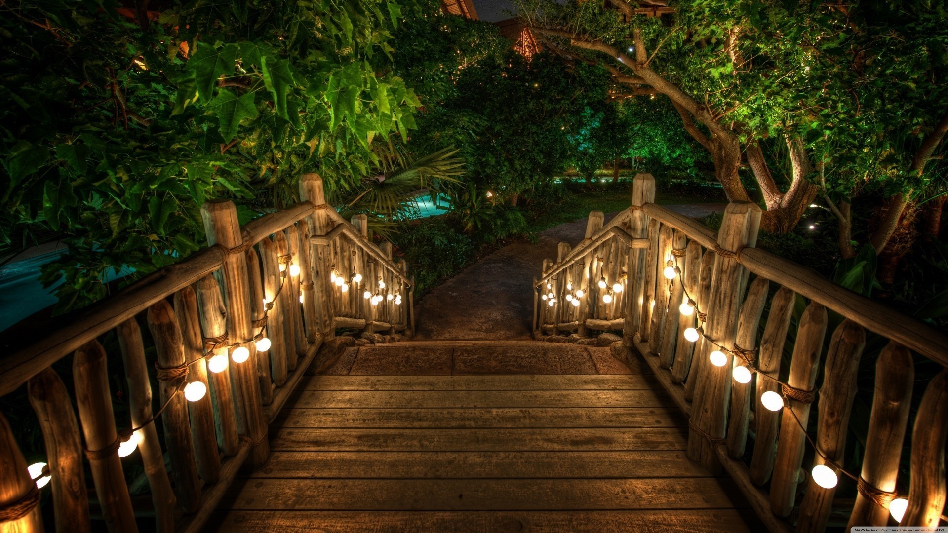 Wooden bridge with lights in a garden at night HD Wallpaper