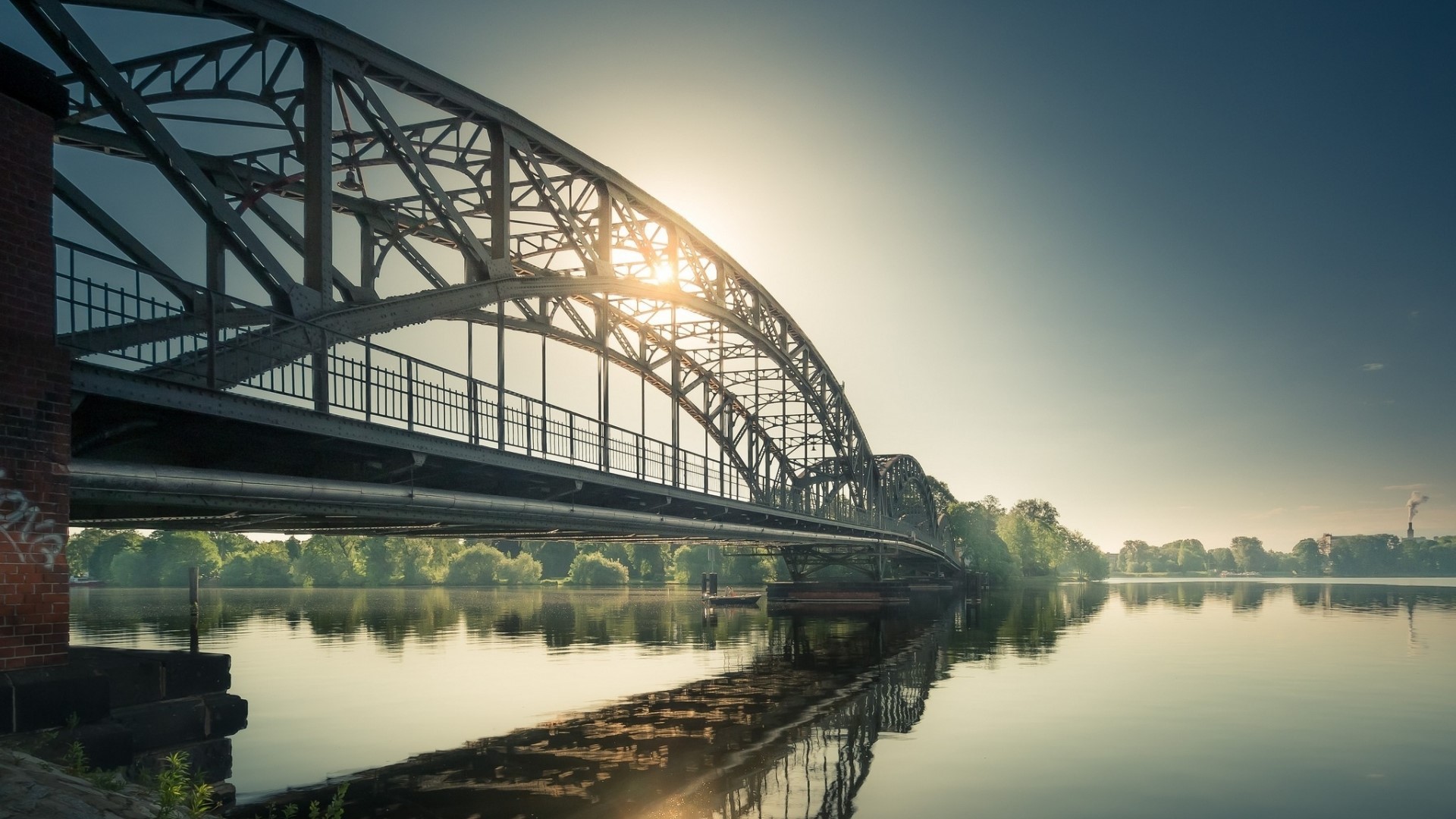 Steel bridge over a calm river at sunrise HD Wallpaper