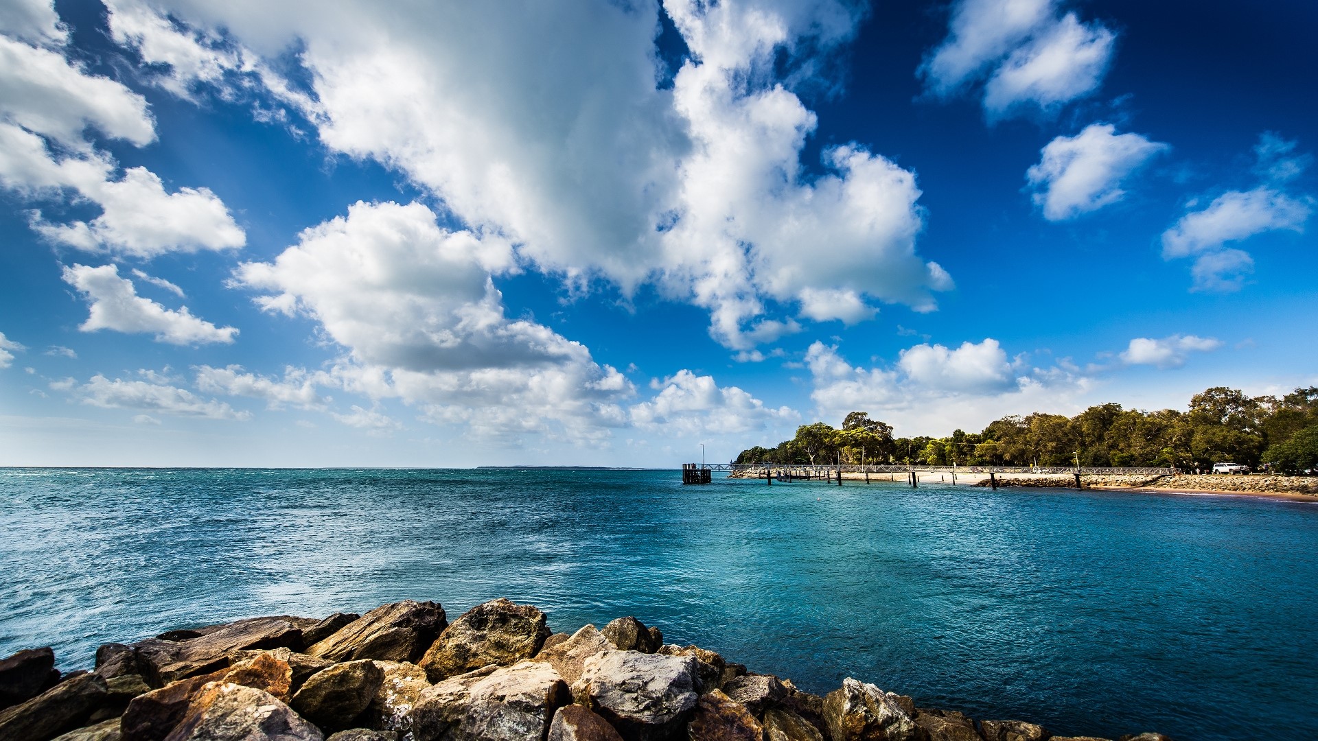 Rocky shore and blue sea under cloudy sky HD Wallpaper