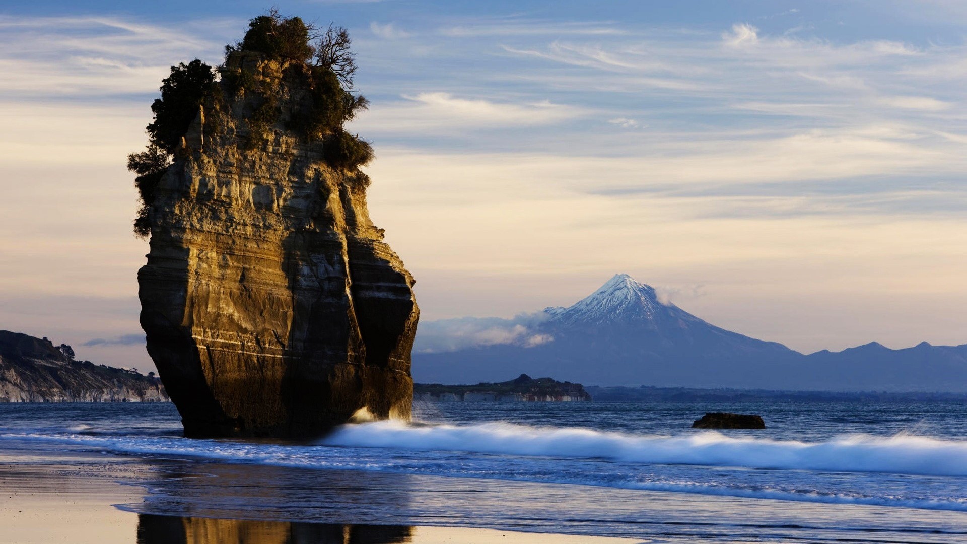 Seaside cliff with mountain in background HD Wallpaper