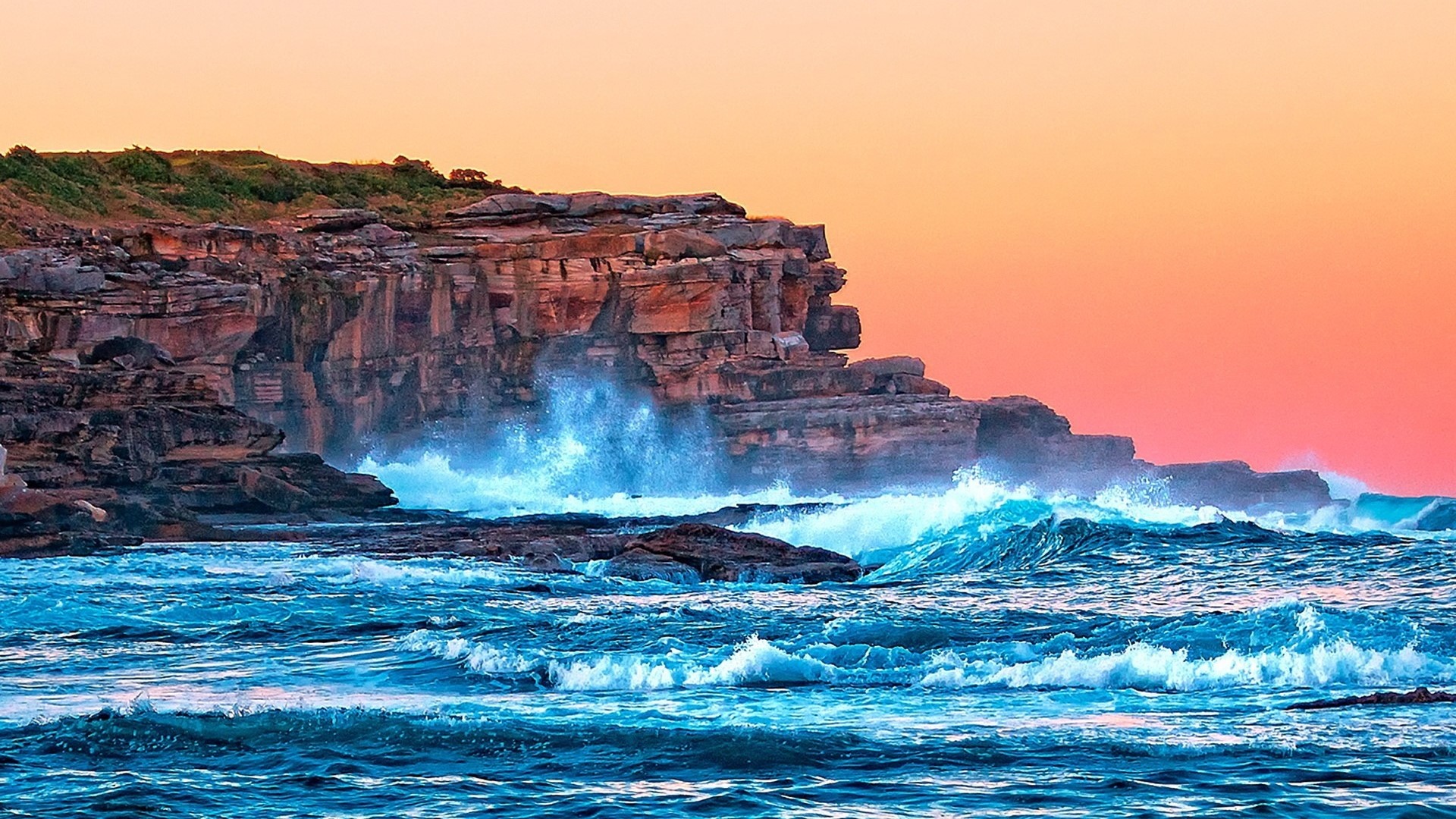 Waves crashing on rocky cliffs at sunset HD Wallpaper