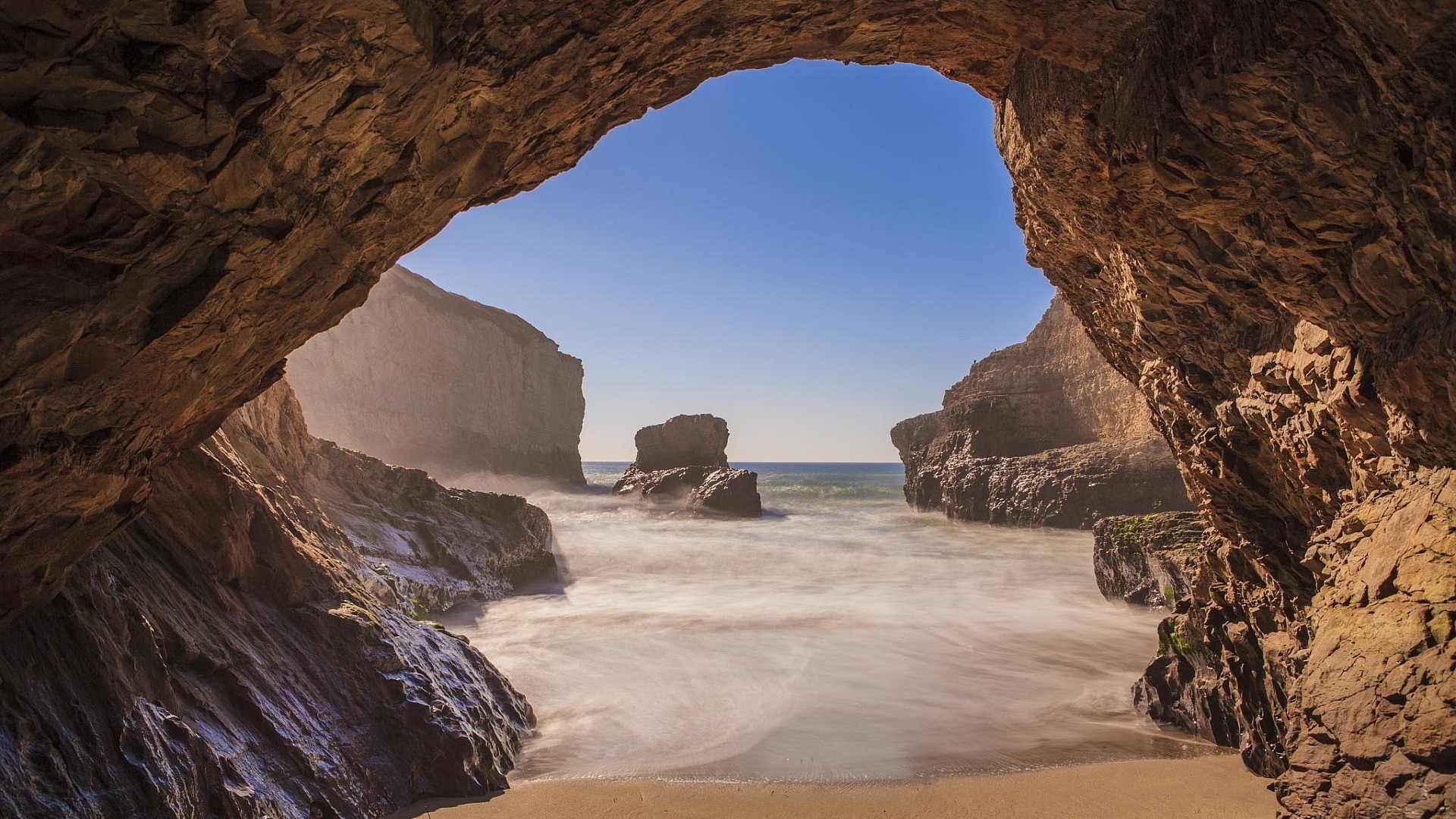 Sea cave with ocean and rock formations HD Wallpaper