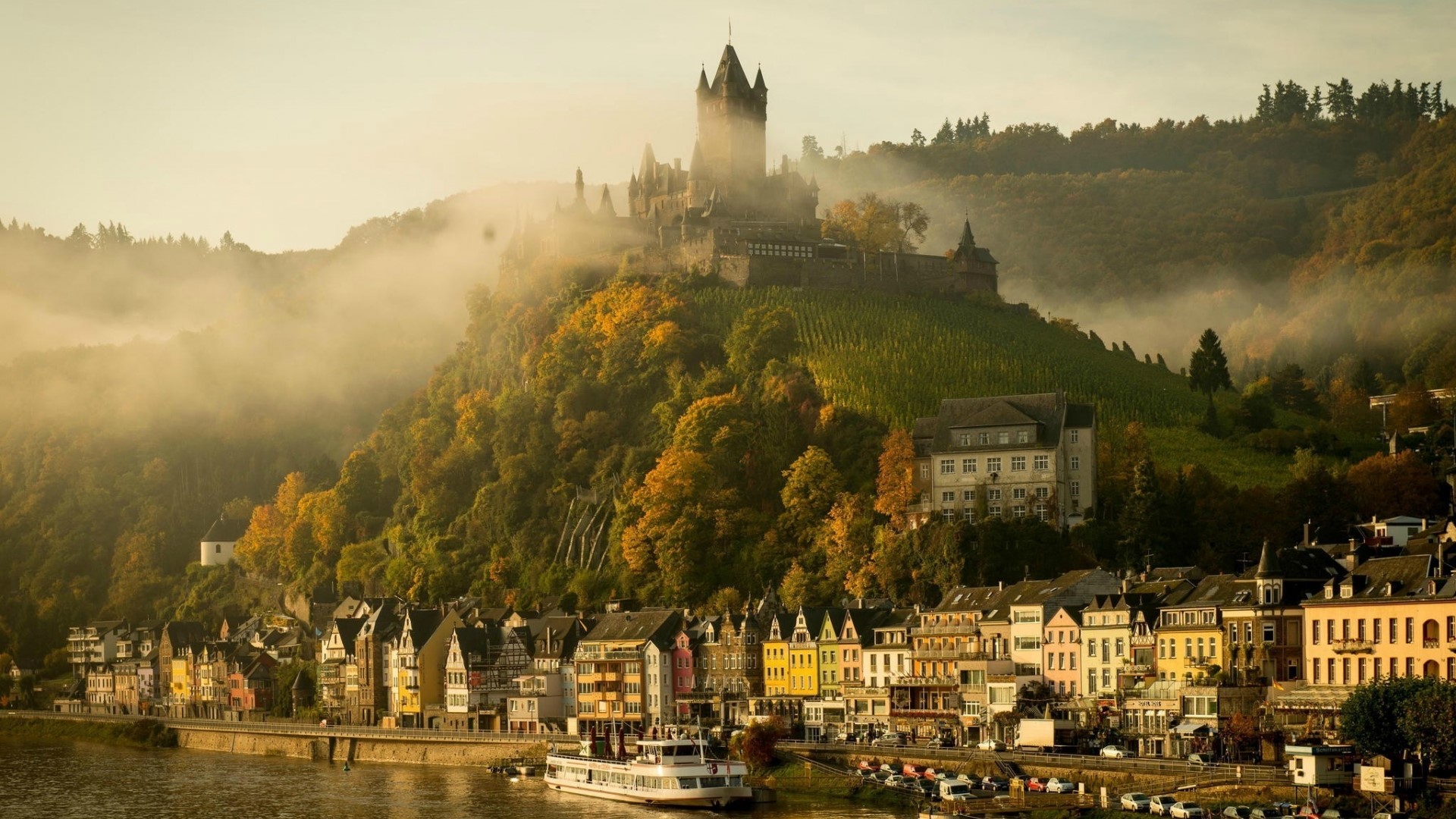 Castle on a hill above a river village HD Wallpaper