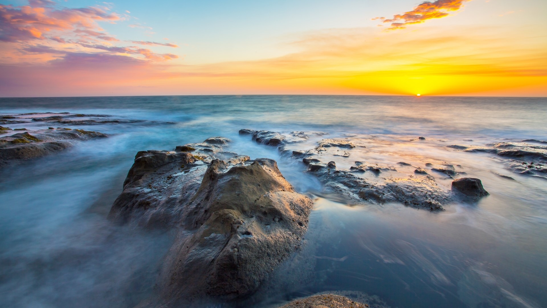 Sunset over the ocean with rocks HD Wallpaper