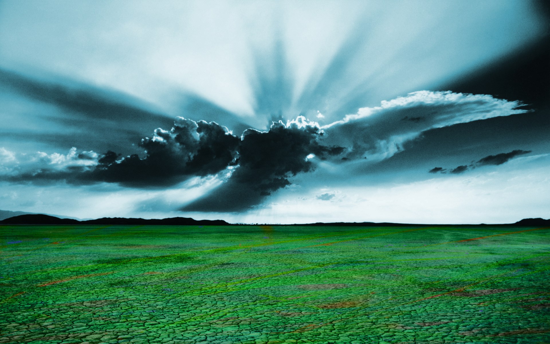 Stormy sky over a cracked green field HD Wallpaper