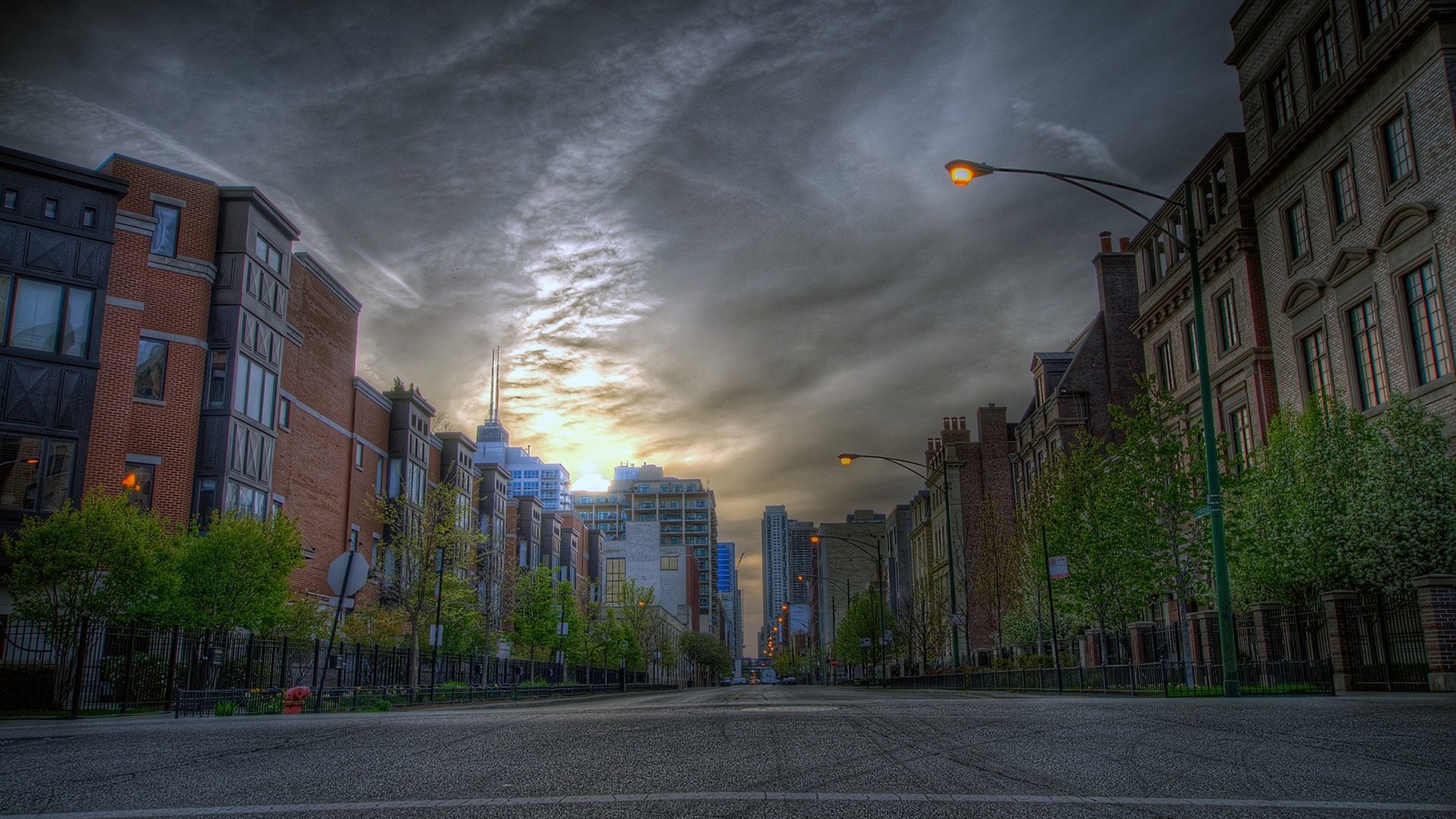 City street with buildings and cloudy sky HD Wallpaper