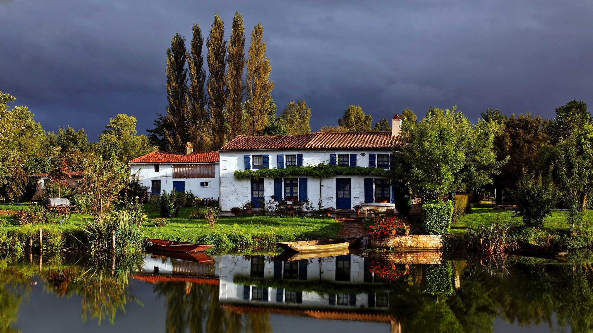 White house with blue shutters by a lake HD Wallpaper