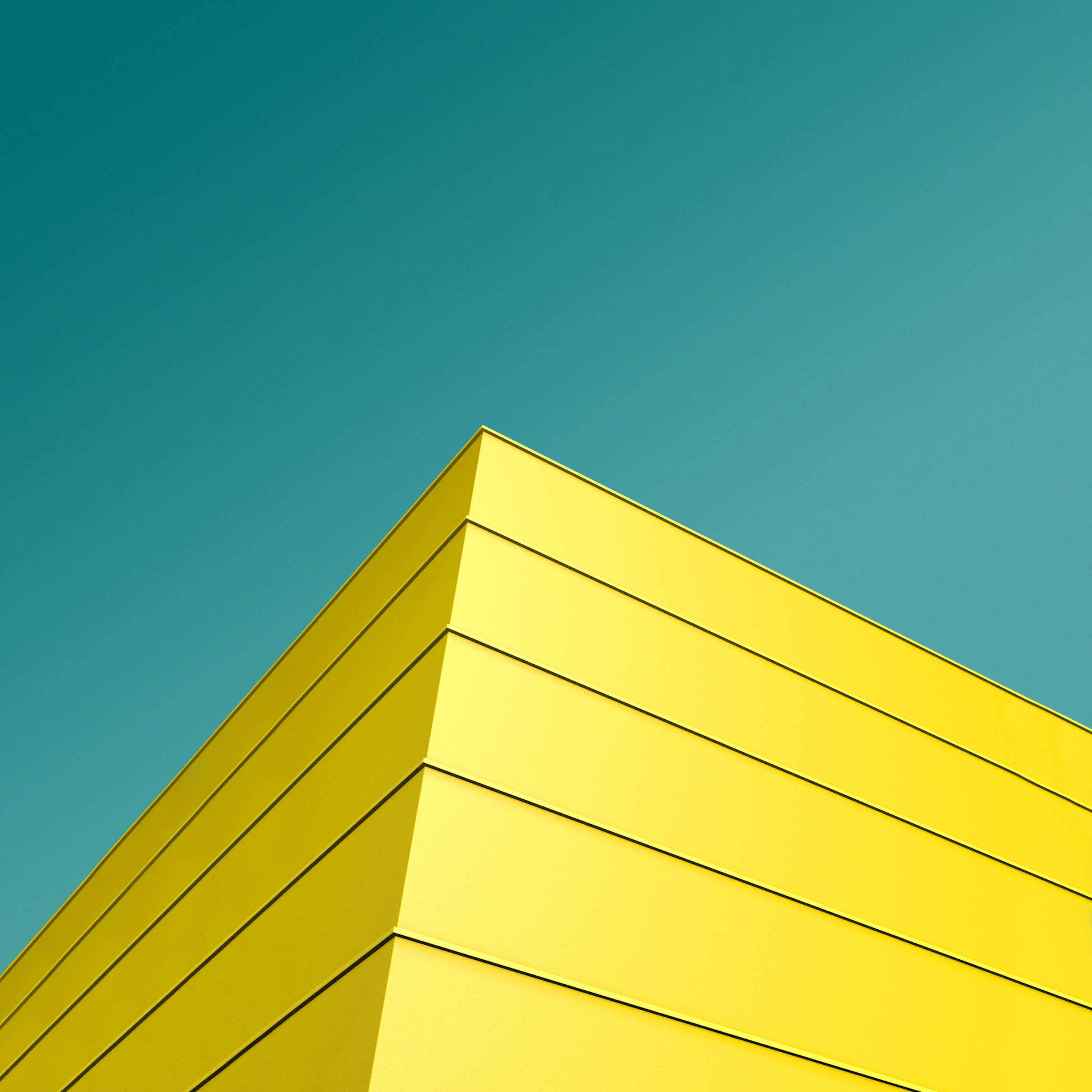 Yellow geometric building corner against teal sky HD Wallpaper